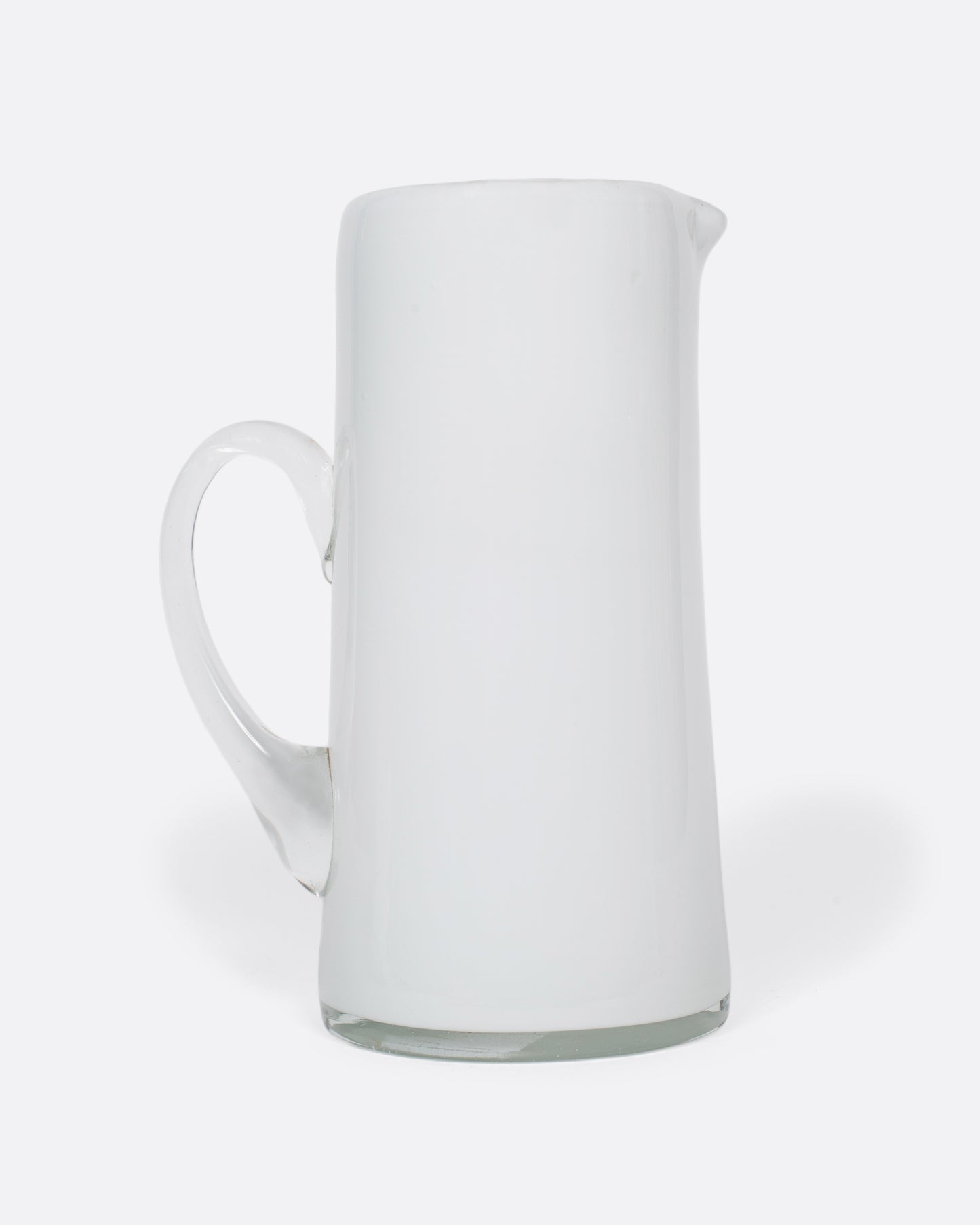 A vintage white cased glass pitcher. Two layers of white glass add depth to its color, creating an elegant, sleek look.