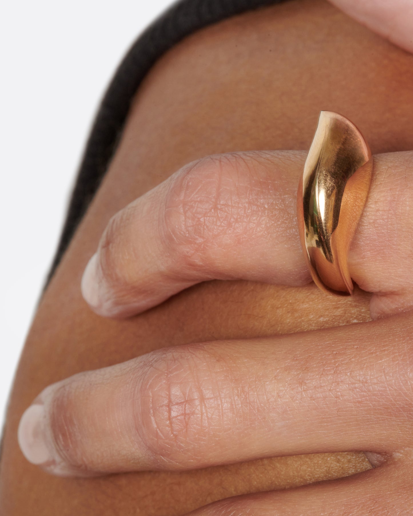 An abstract shaped gold ring with a yin yang symbol cutout on the inside of the band.