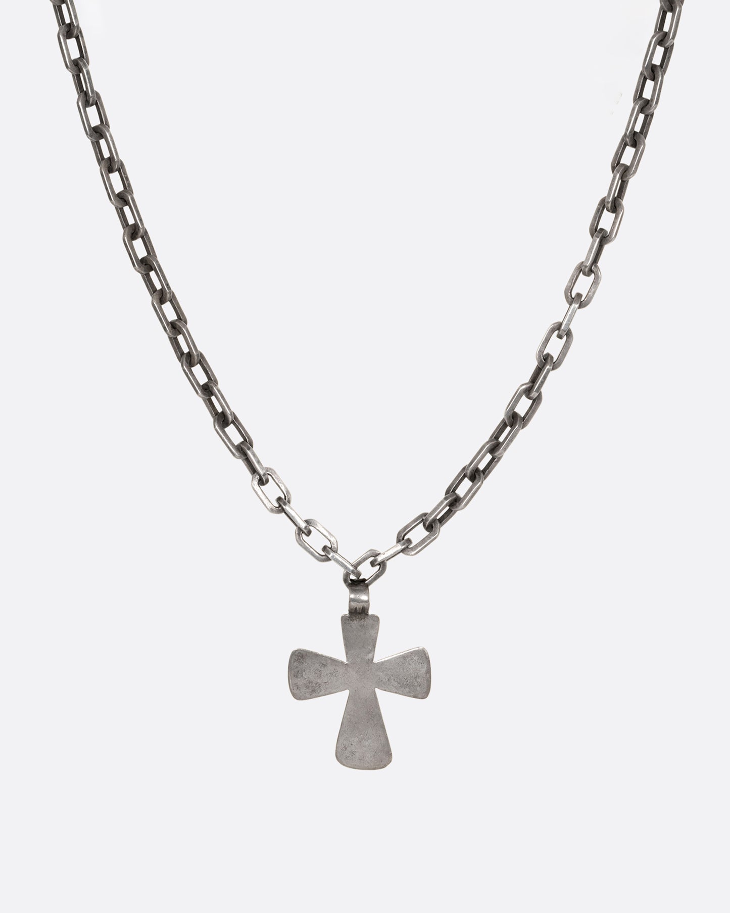 A heavy cable chain necklace with a large cross pendant. Shown up close from the front.