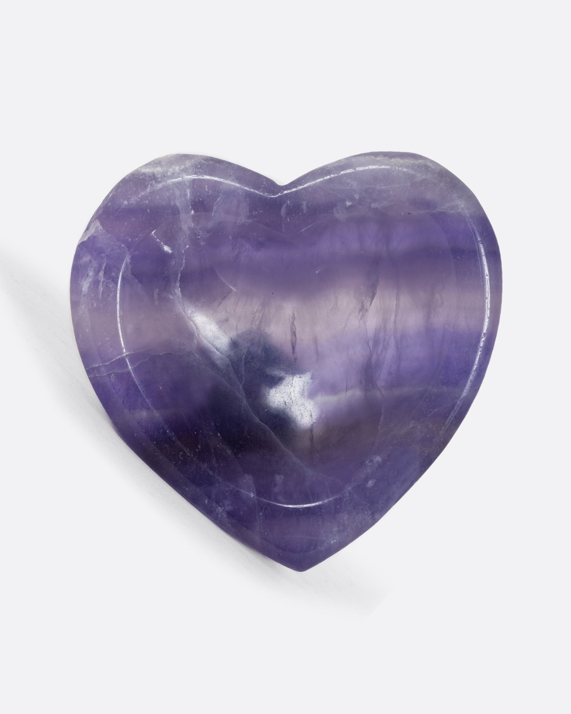 A purple fluorite stone heart shaped bowl. Shown from the front.