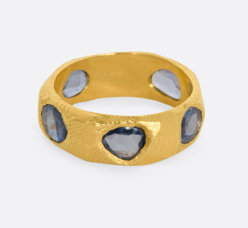 A yellow gold ring with five large blue rose cut sapphires.