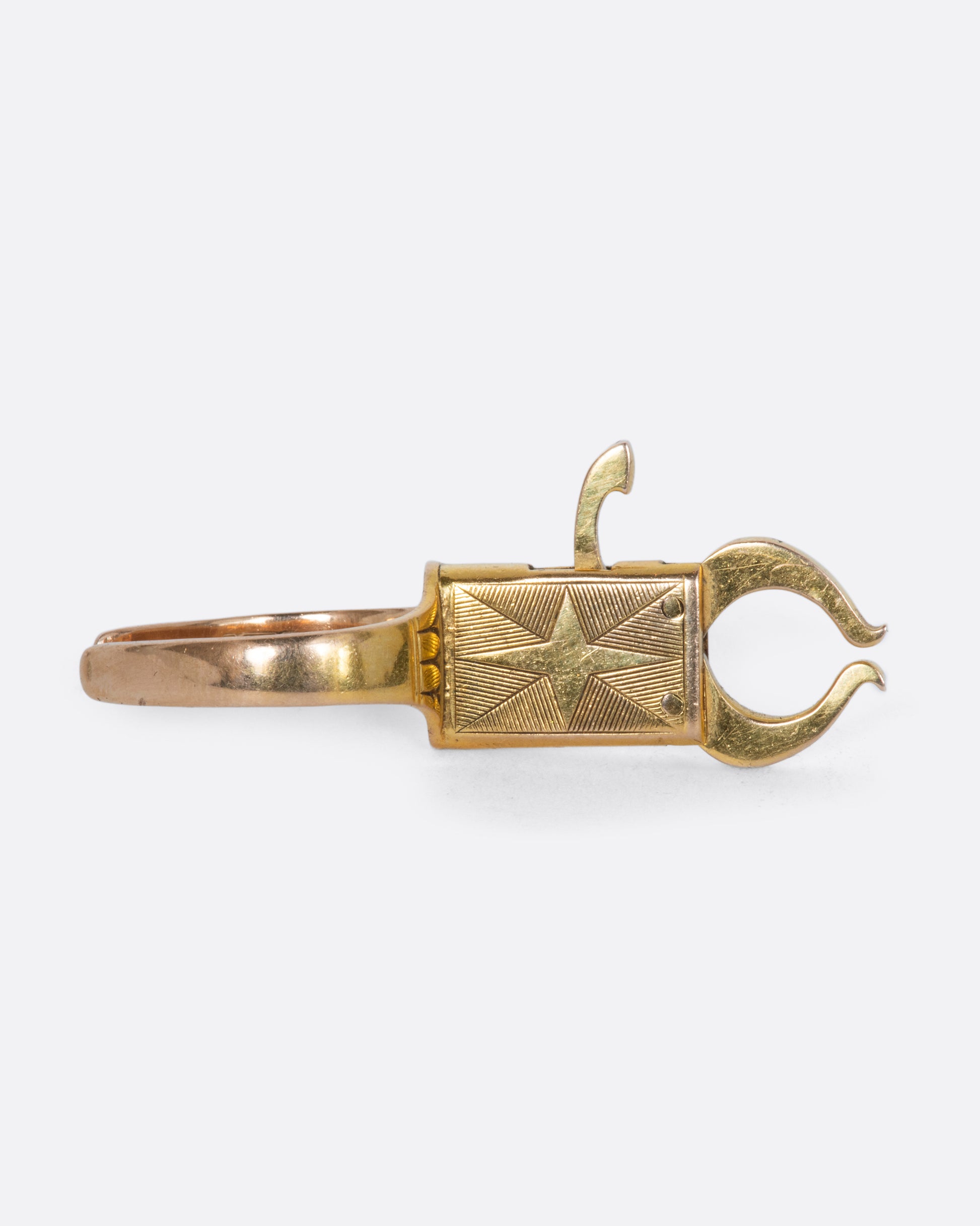 A yellow gold ring with a grasping mechanism. View straight on.