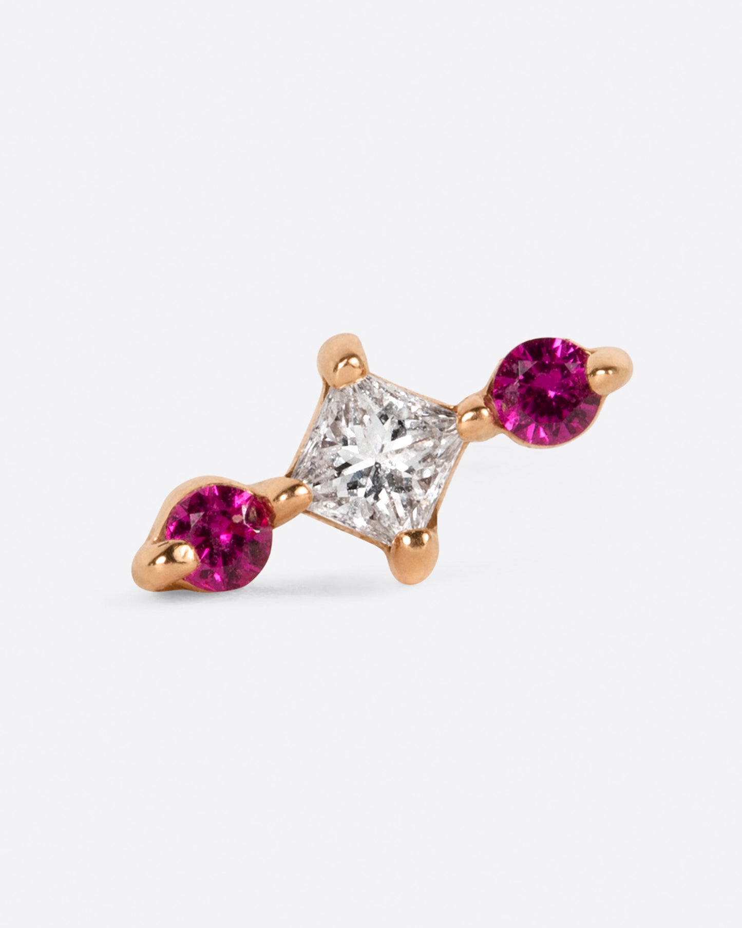 A princess cut diamond is punctuated with round pink sapphires. View from the front.