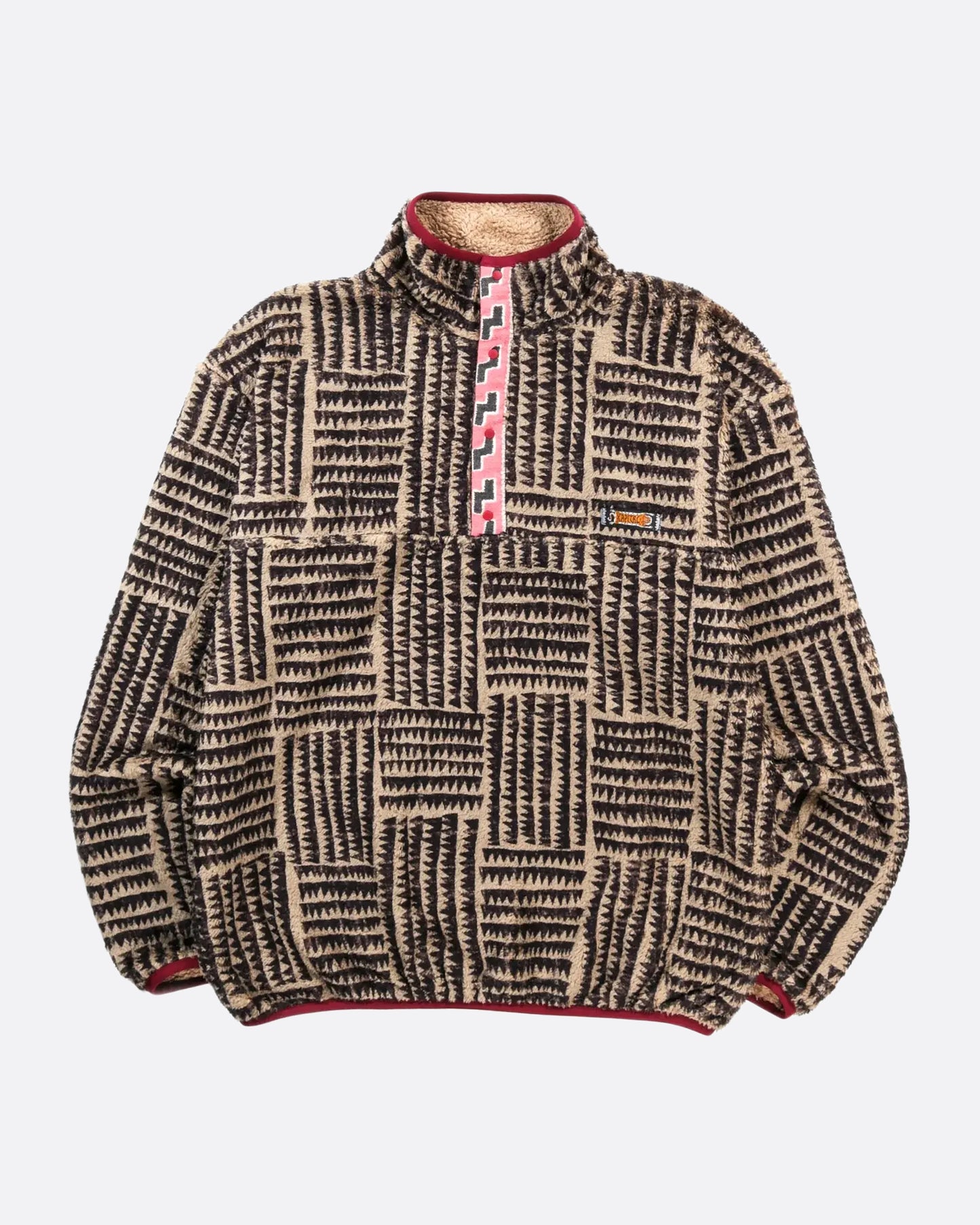 A brown a tan zig zag print fleece pullover with pink detail at the front closure. View from the front laying flat.