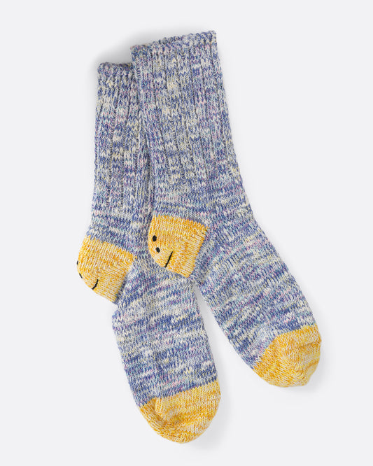 A pair of cotton blend melange purple socks with yellow smiley heels. View laying flat.