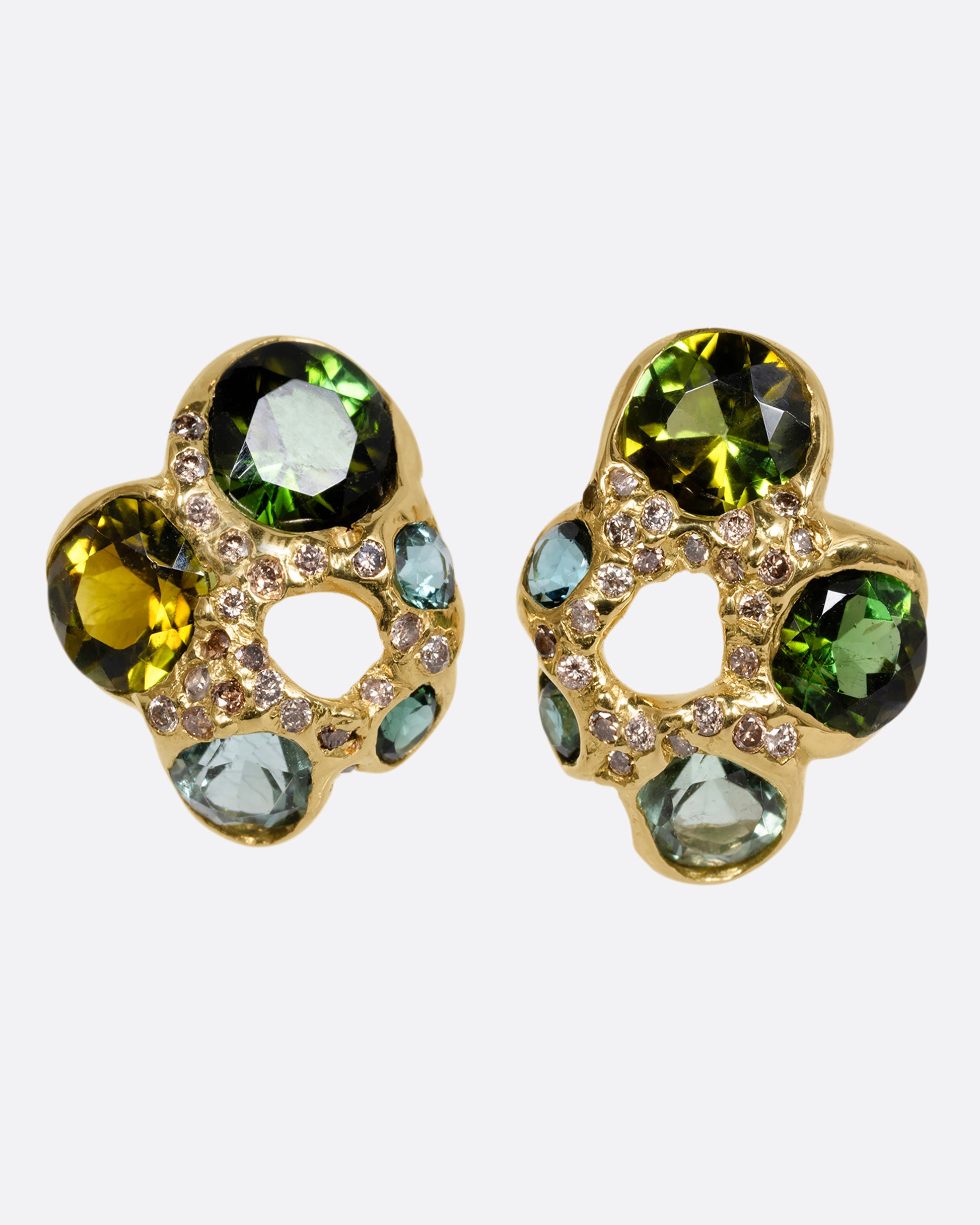 Yellow gold stud earrings with open centers and free- form tourmalines in varying shades of green. Tiny white diamonds are peppered throughout. Shown from the front.