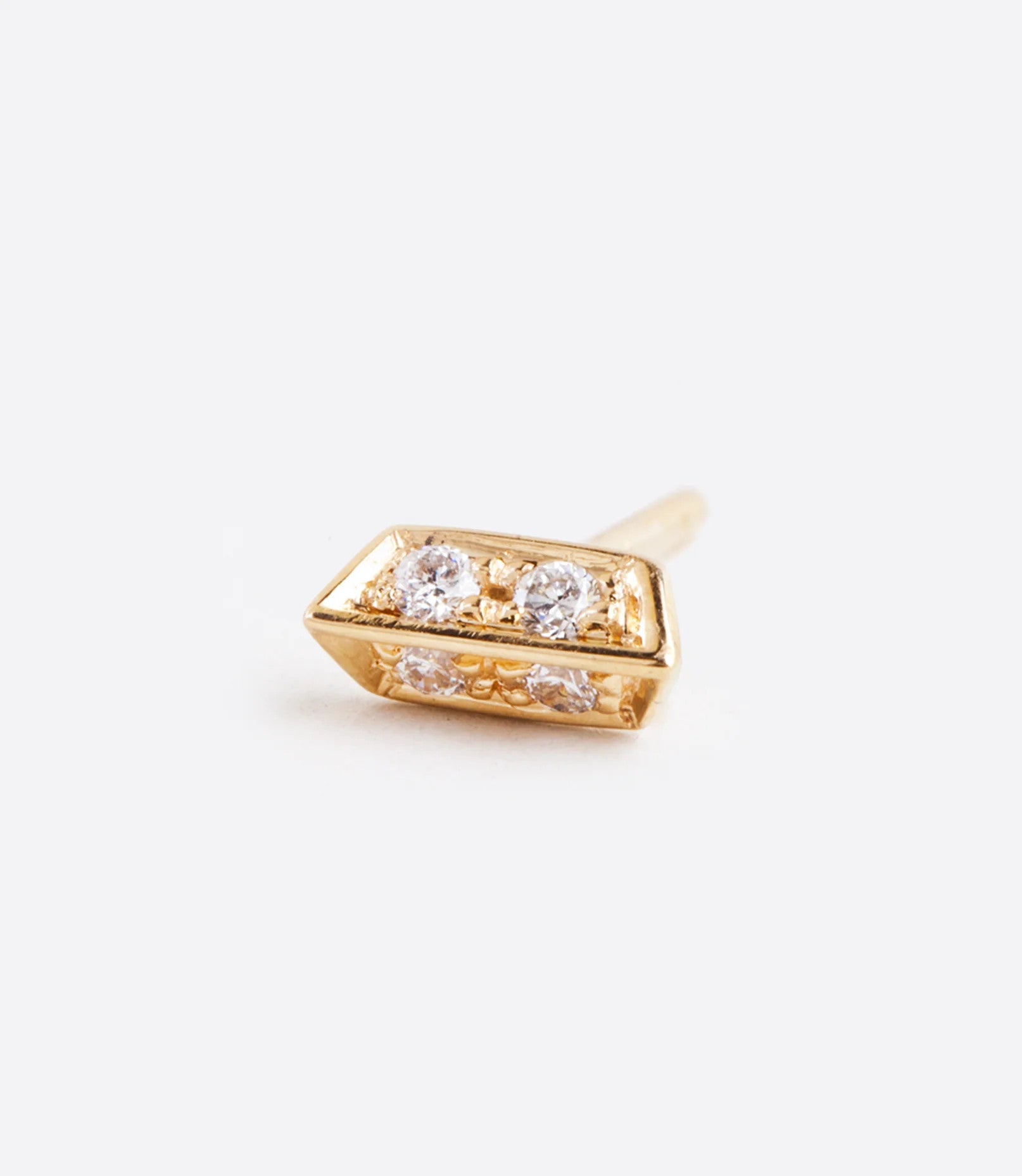 A yellow gold bar stud earring with two angled sides and four diamonds. Shown lying on its side from the front.