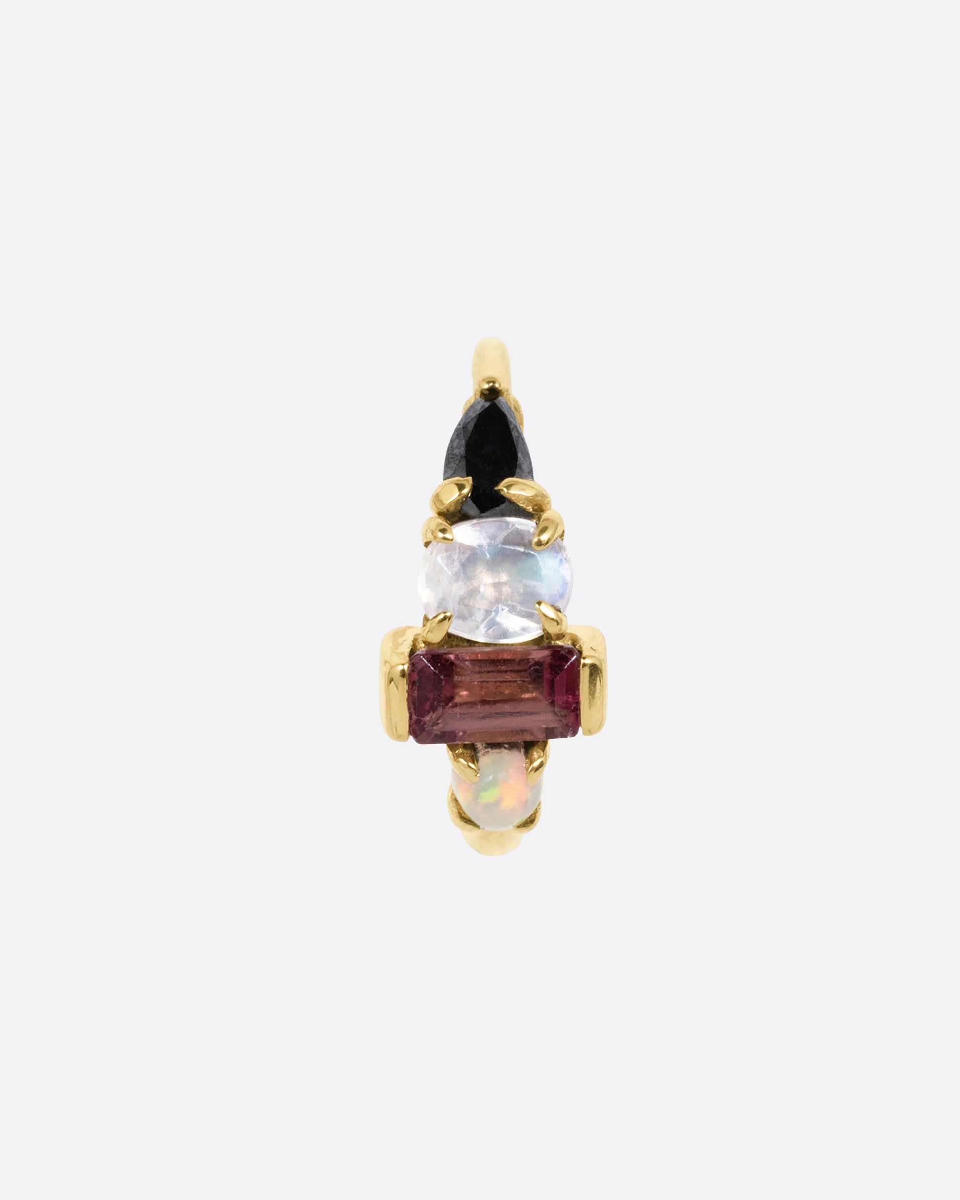 A yellow gold huggie hoop with a gemstone stack of black diamond, moonstone, tourmaline, and opal. Shown from the front.