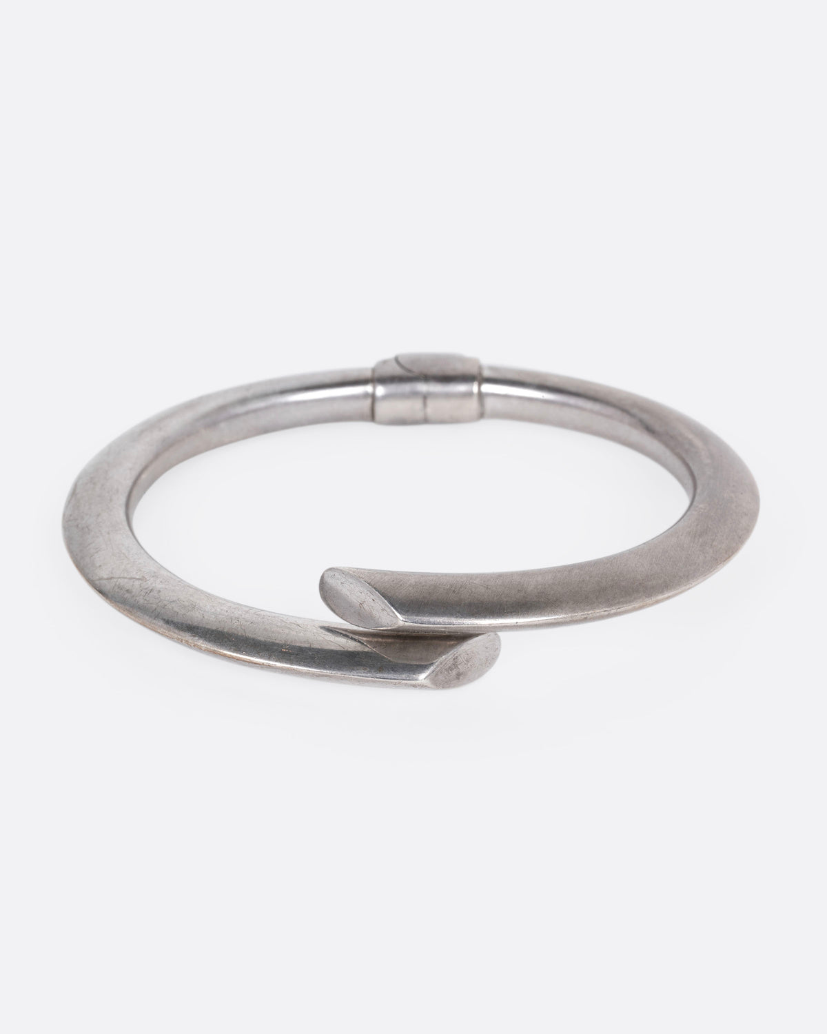 A silver wrap bracelet with hinged back, shown from the front.