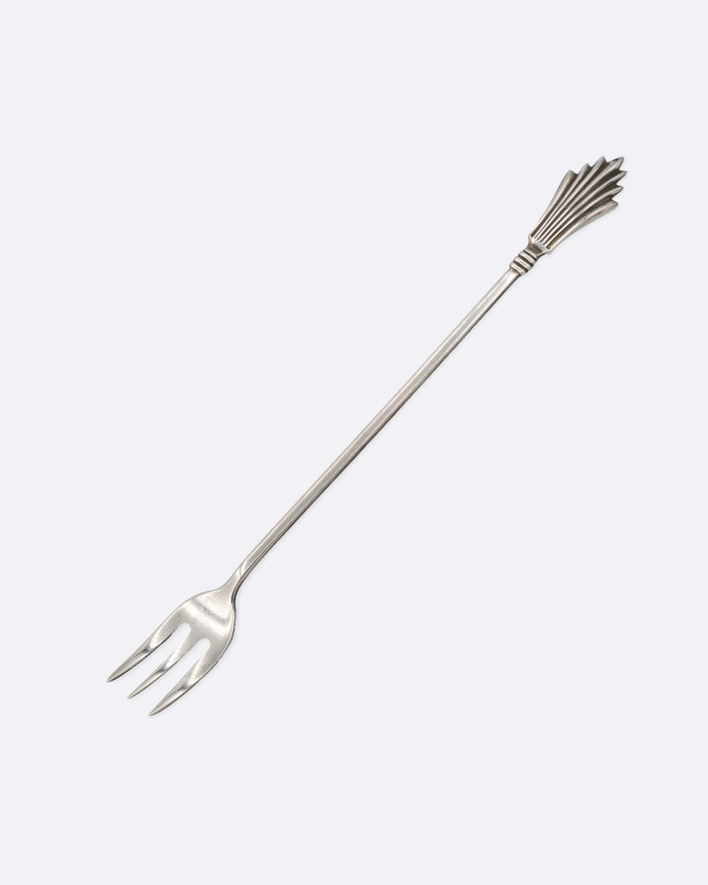 A silver three pronged fork with a fan shape at the top of the handle. Shown from the front.