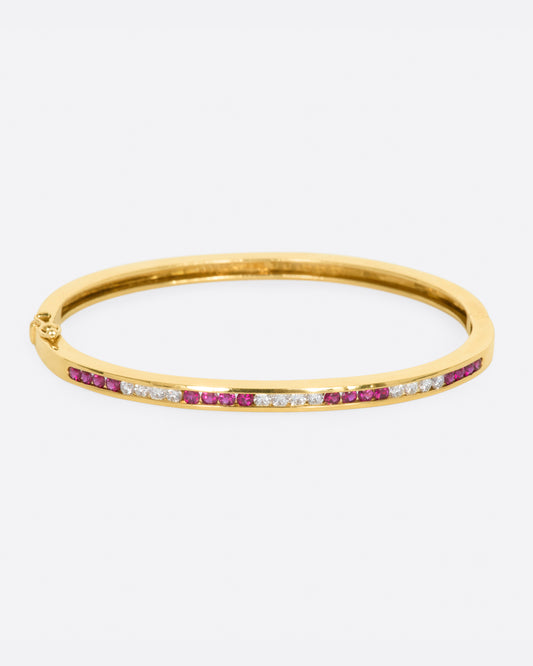 Yellow gold bracelet with alternating sections of channel set rubies and diamonds. View from the front.