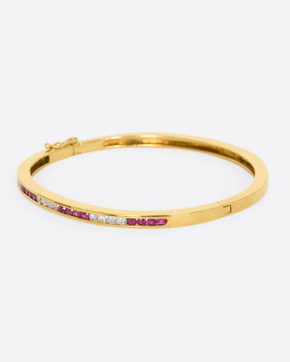 Yellow gold bracelet with alternating sections of channel set rubies and diamonds. View from the left side.