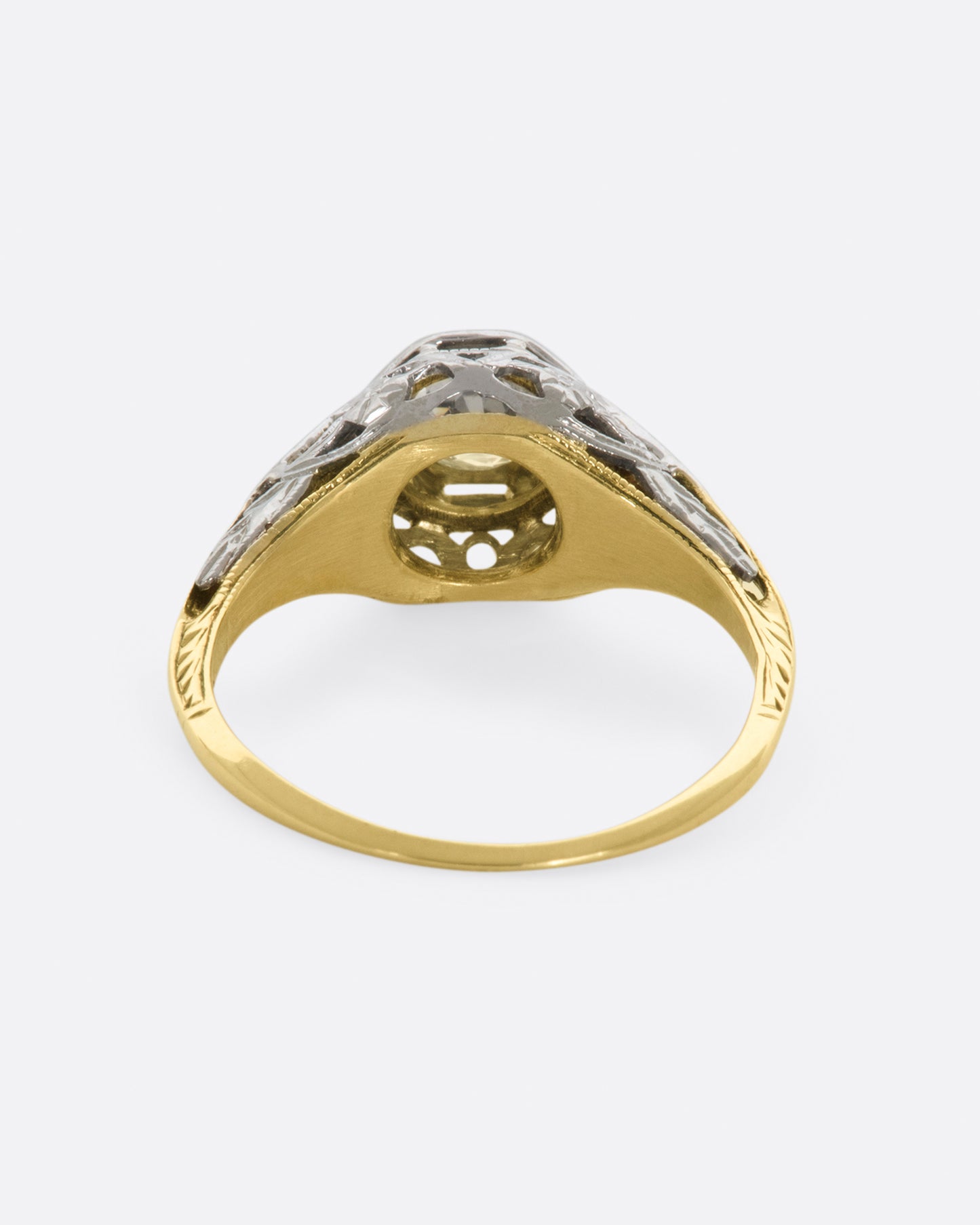 A white gold filigree ring with old mine cut center diamond and a yellow gold band. View from the back.