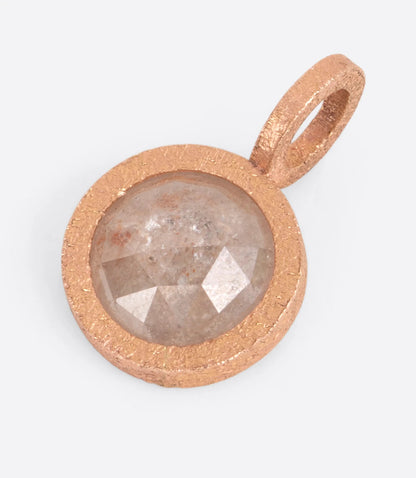 A rose  gold pendant with a central diamond, shown lying flat.