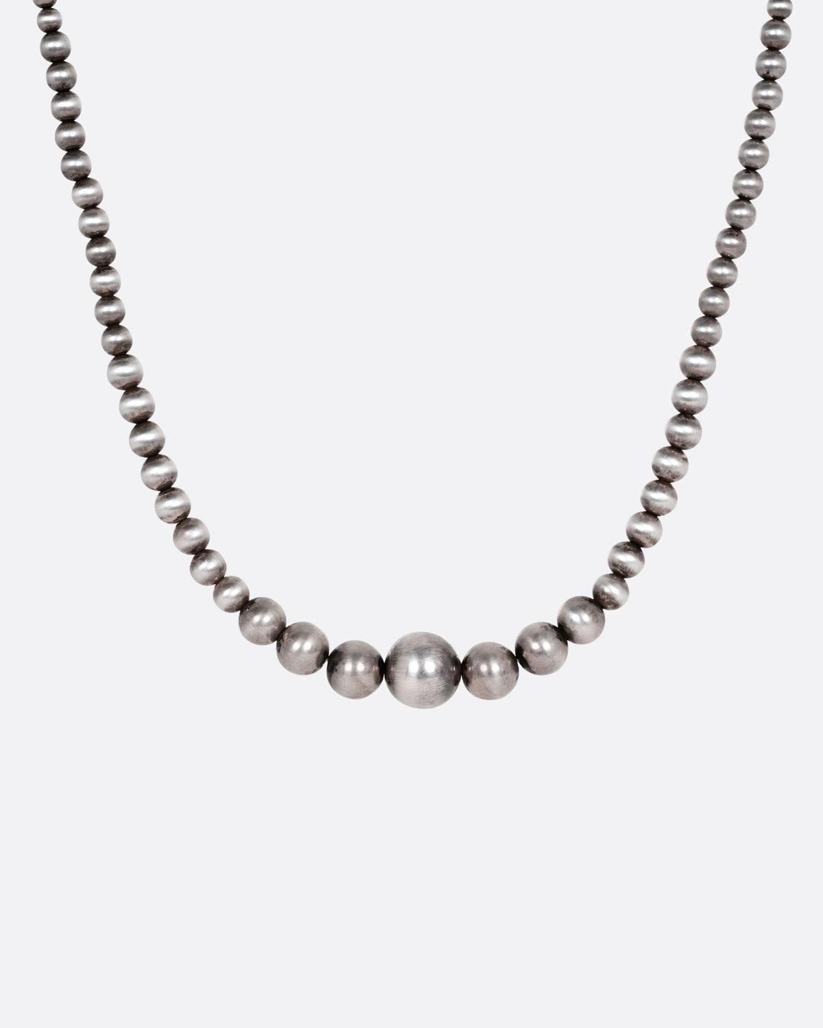 A silver beaded necklace, shown from the front.