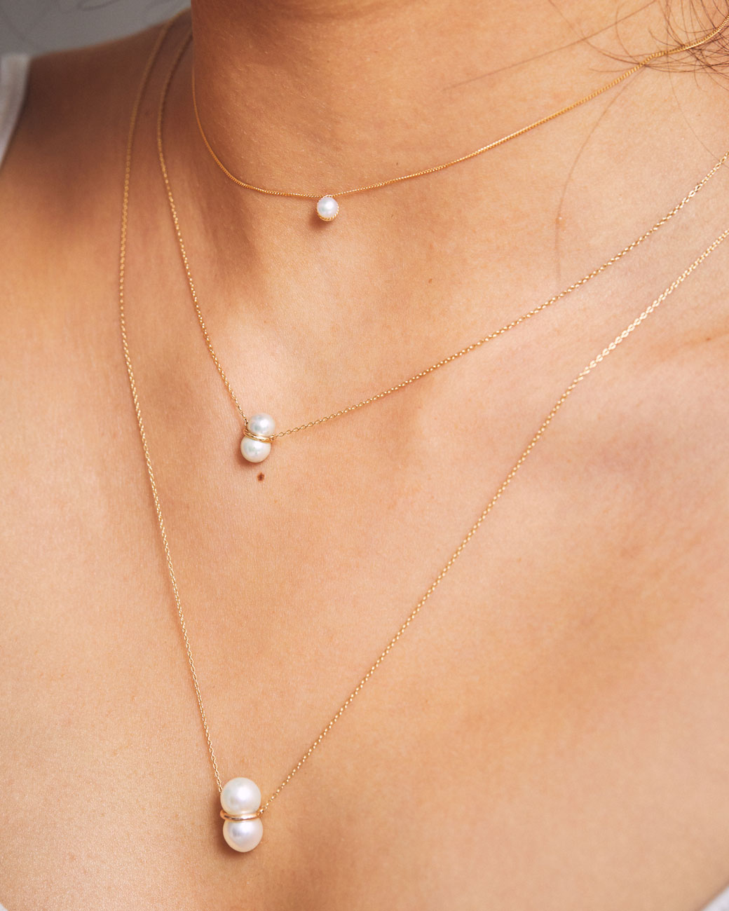 womans neck with three pearl necklaces of different sizes on. the medium one is the one on this product page.