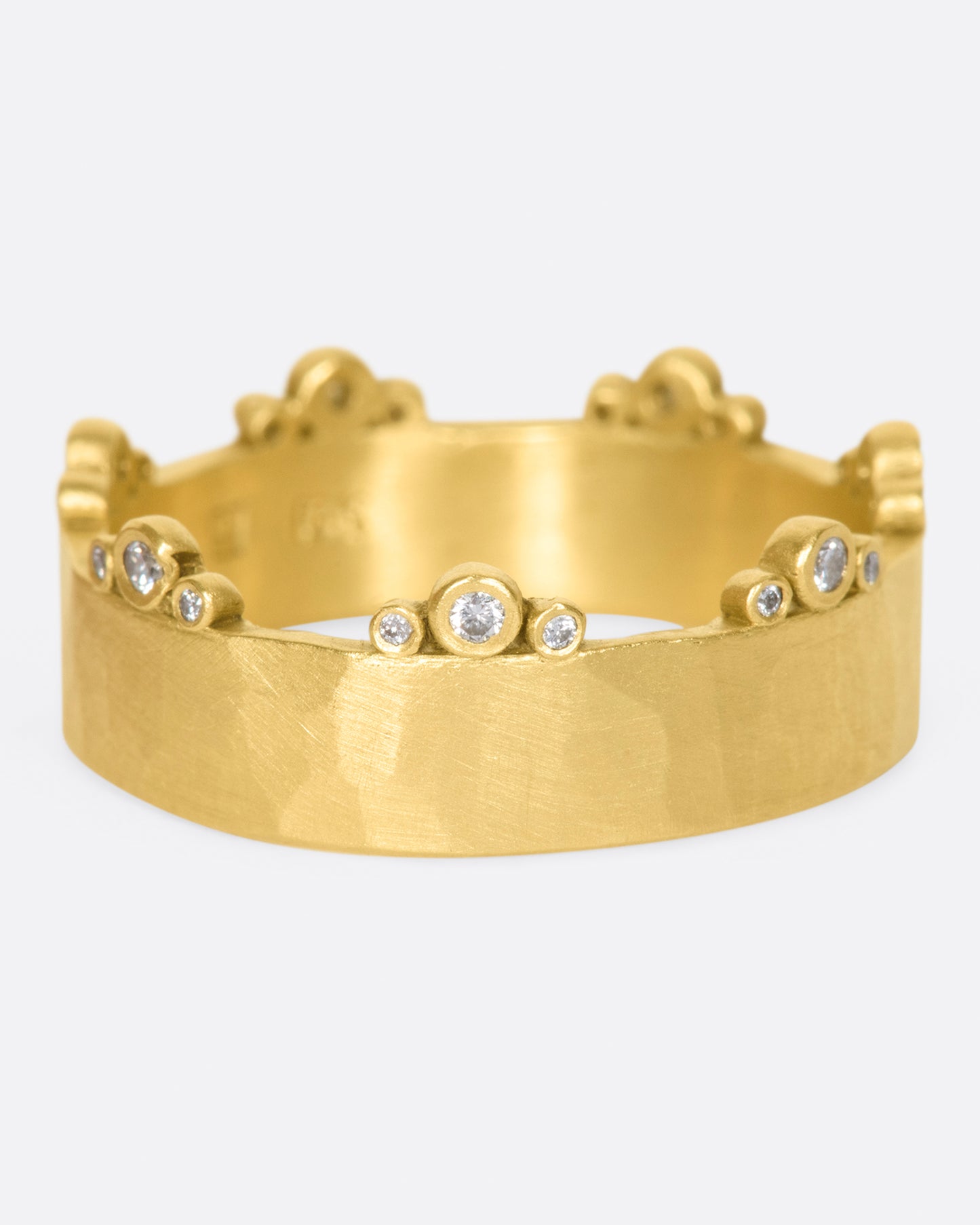 A wide, hammered, matte gold band with stations of diamonds along one edge.