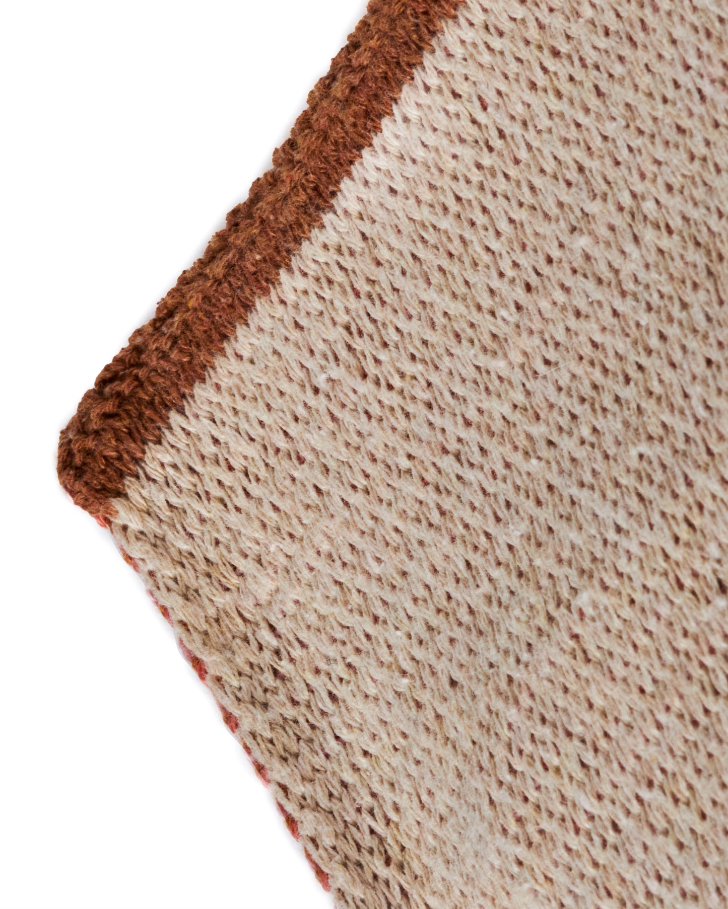 A long knit jacquard throw blanket featuring a minimalist design inspired by the Mojave desert, shown close up.