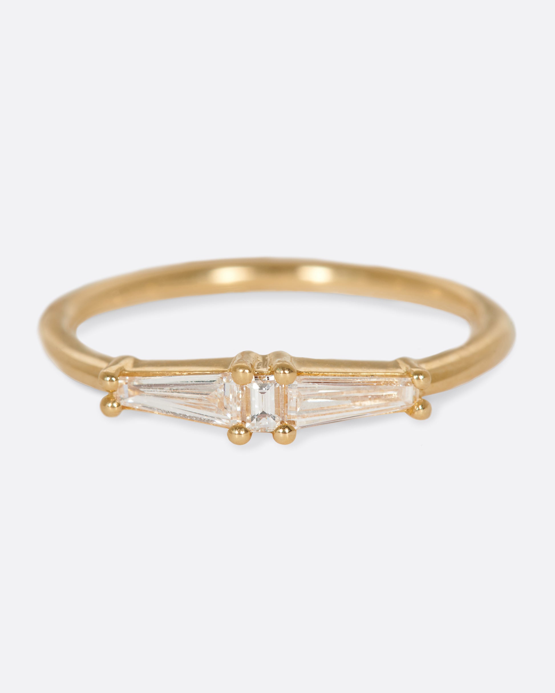 A ring featuring two tapered baguette diamonds and one carre cut diamond; perfect for stacking.