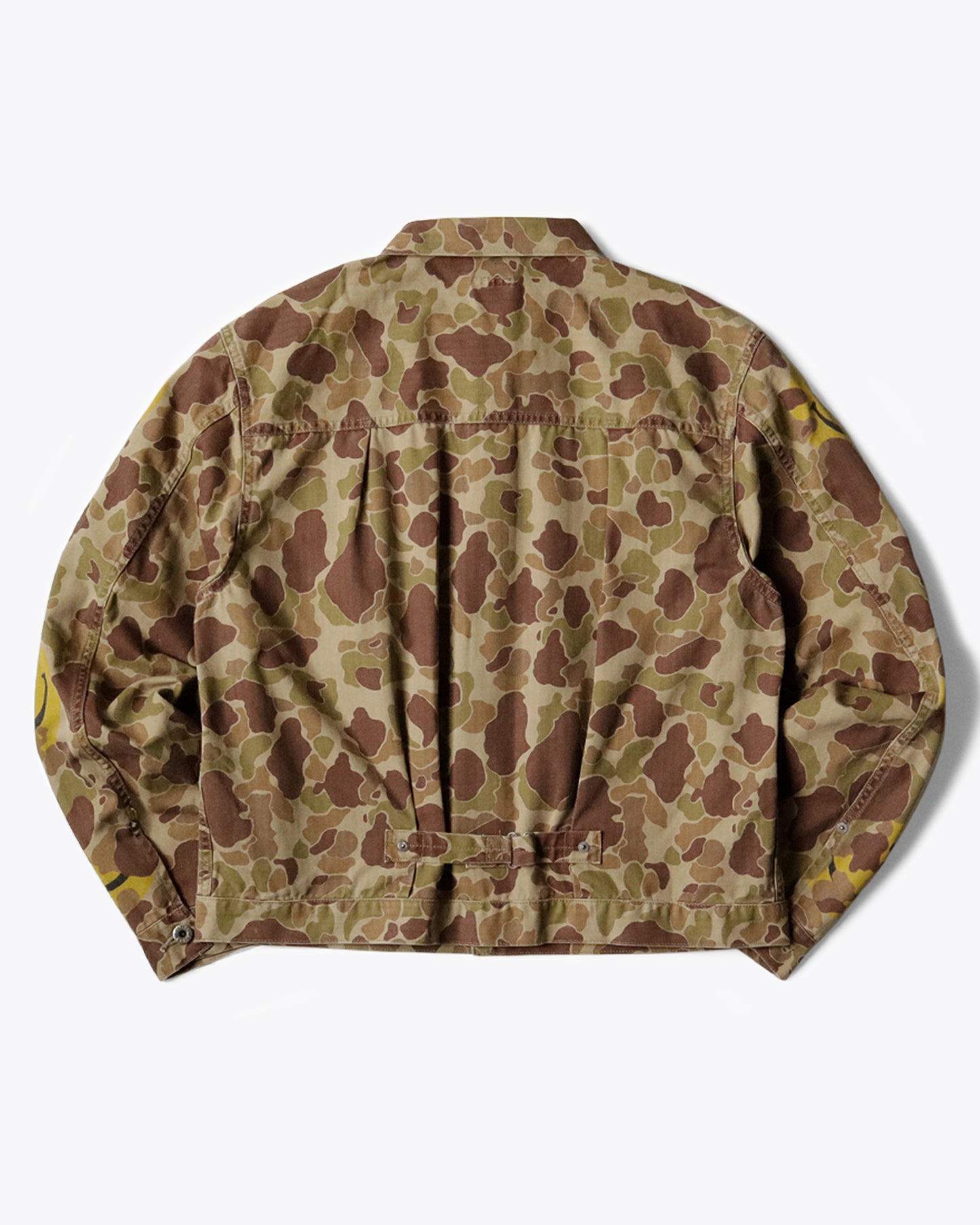 A military-like camouflage 1st jacket with smiley faces peeking out.