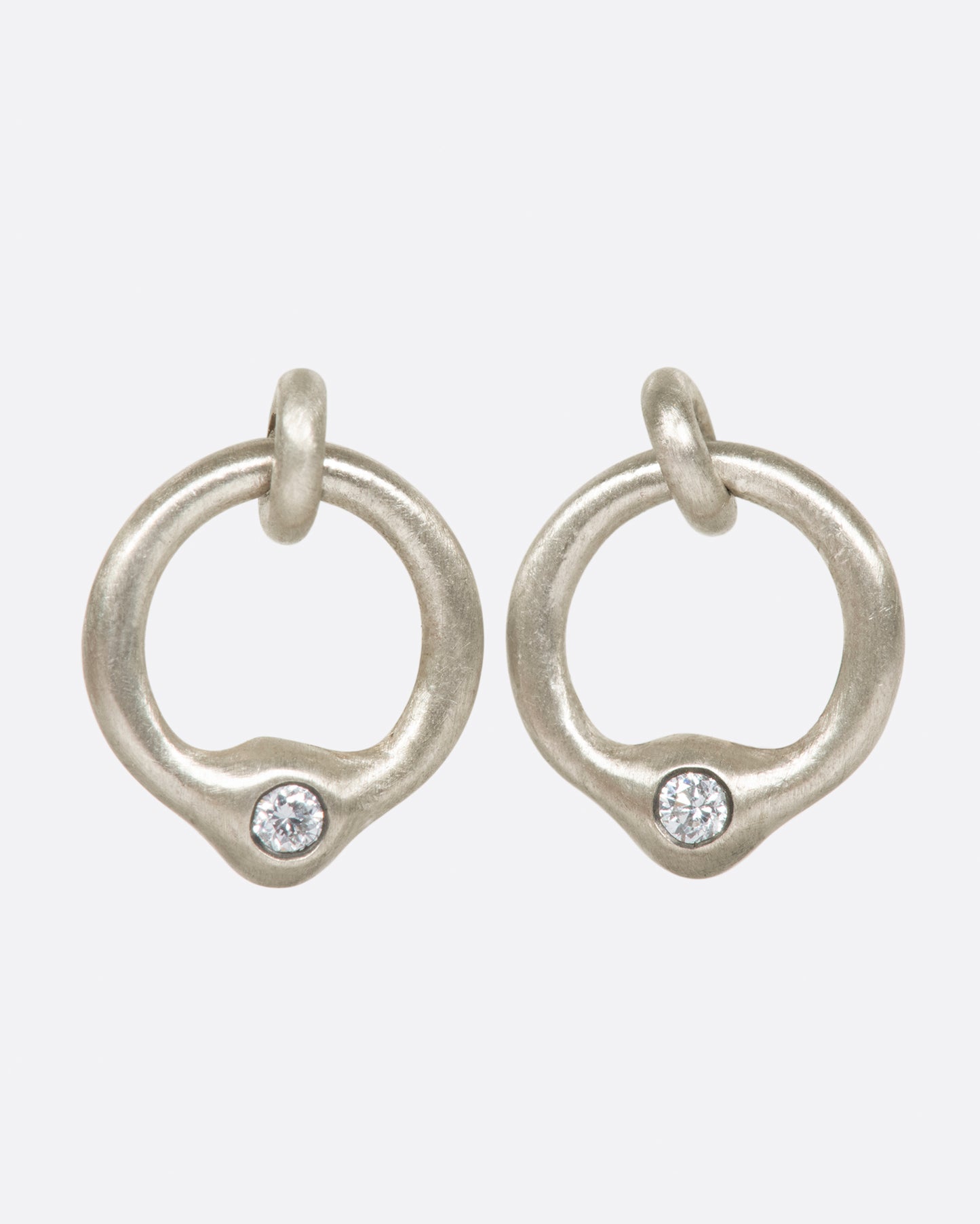 A pair of sterling silver ring stud earrings with diamonds at the bottom, shown from the front.