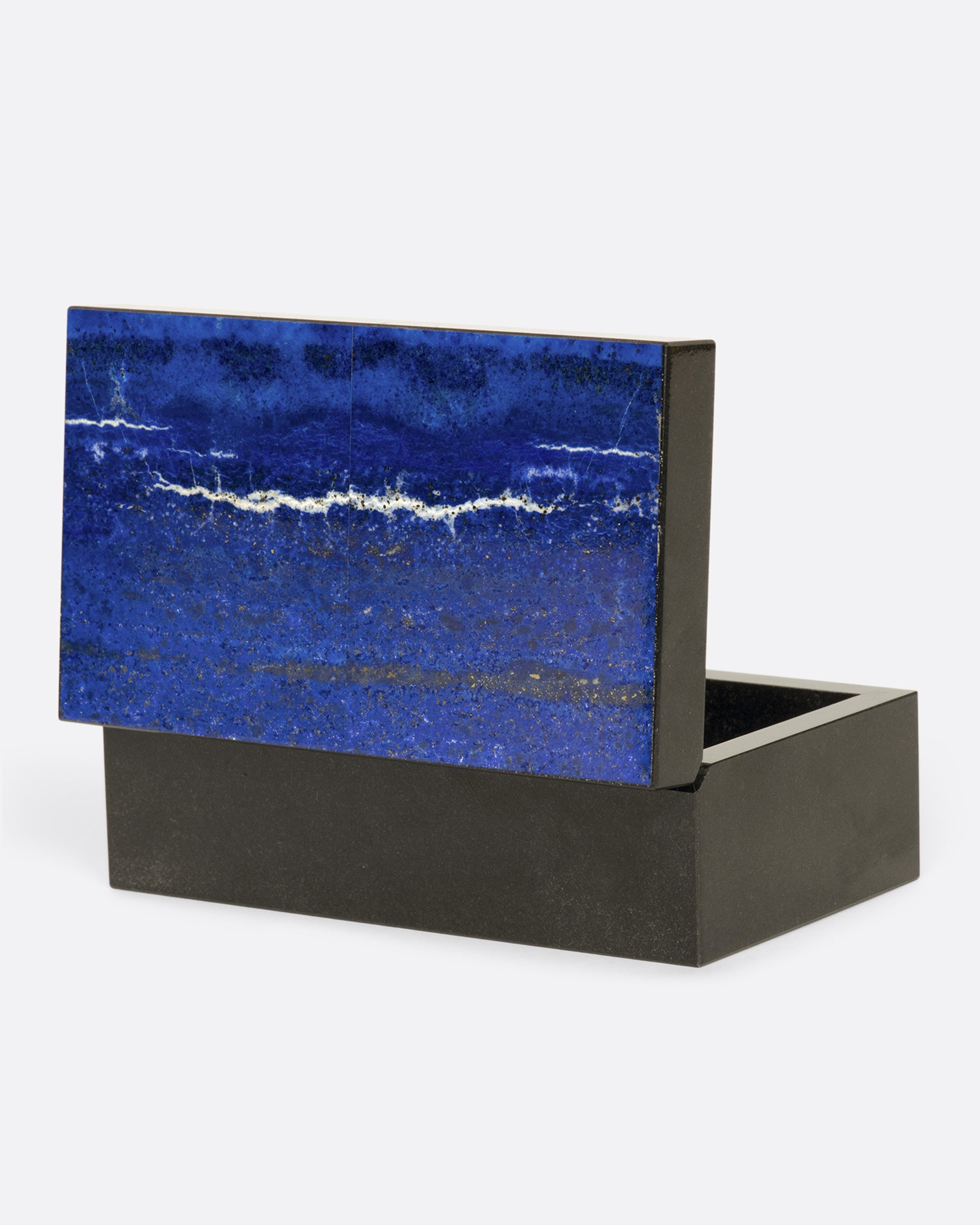 A hinged box made from dark igneous rock with a deep blue layer of lapis on the lid.