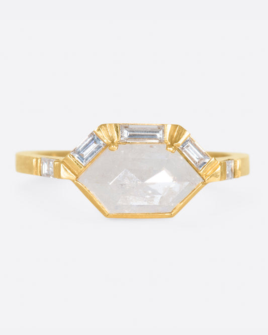 This ring features an east-west set, hexagonal, rose cut gray diamond with a half-halo of baguette diamonds.