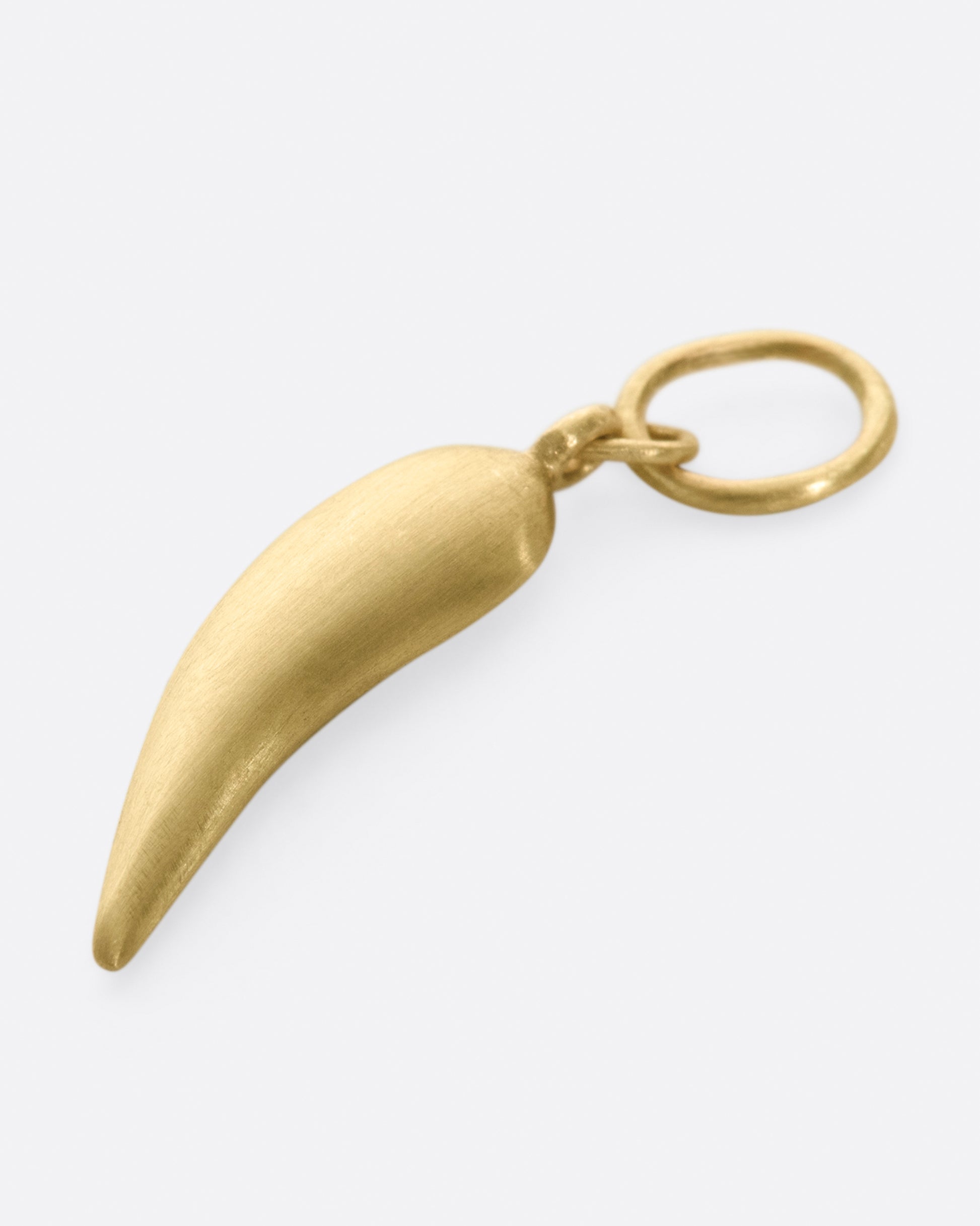 A yellow gold chili shaped charm with five graduated black diamonds. Shown laying flat, from the back.