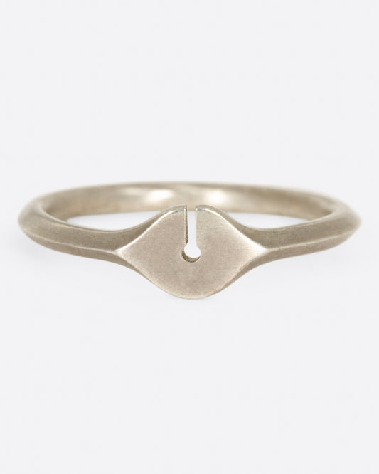 A brush sterling silver ring with a knife-edge band and an elliptical face with a keyhole cutout.