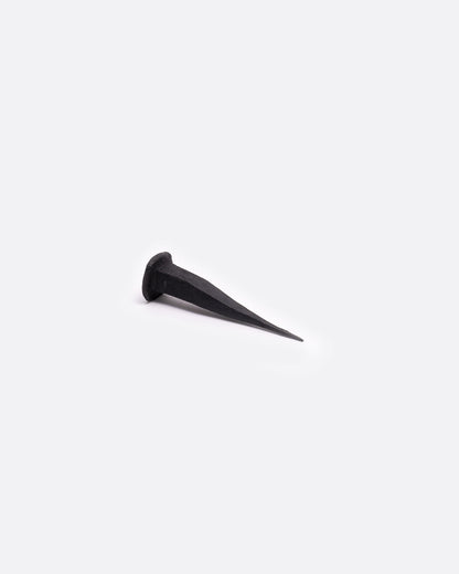 A single flat head iron nail. Shown lying on its side.