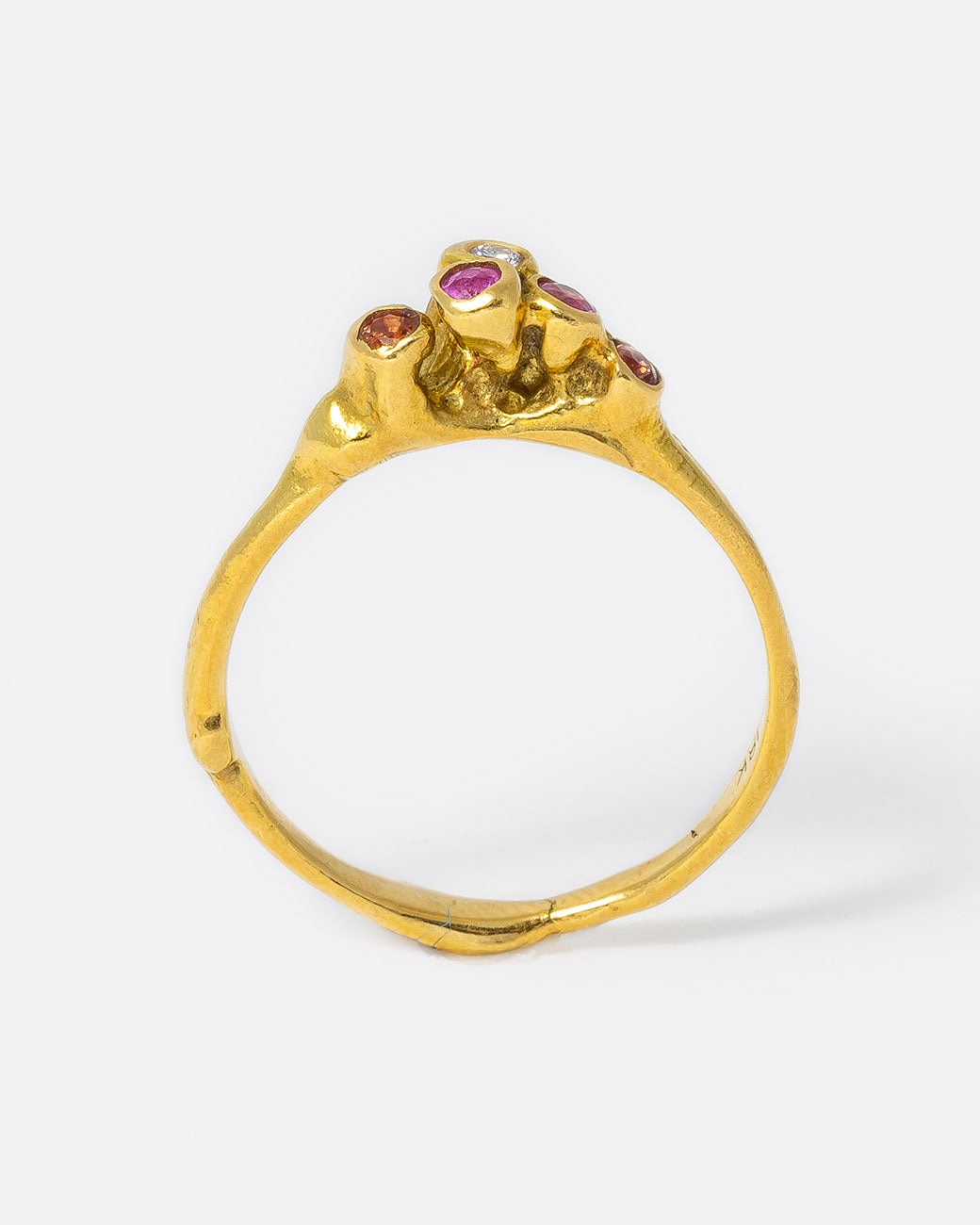 18k yellow gold teeny sea anemone ring with pink sapphires, orange sapphires, and diamonds by Kimberlin Brown, shown from the side.