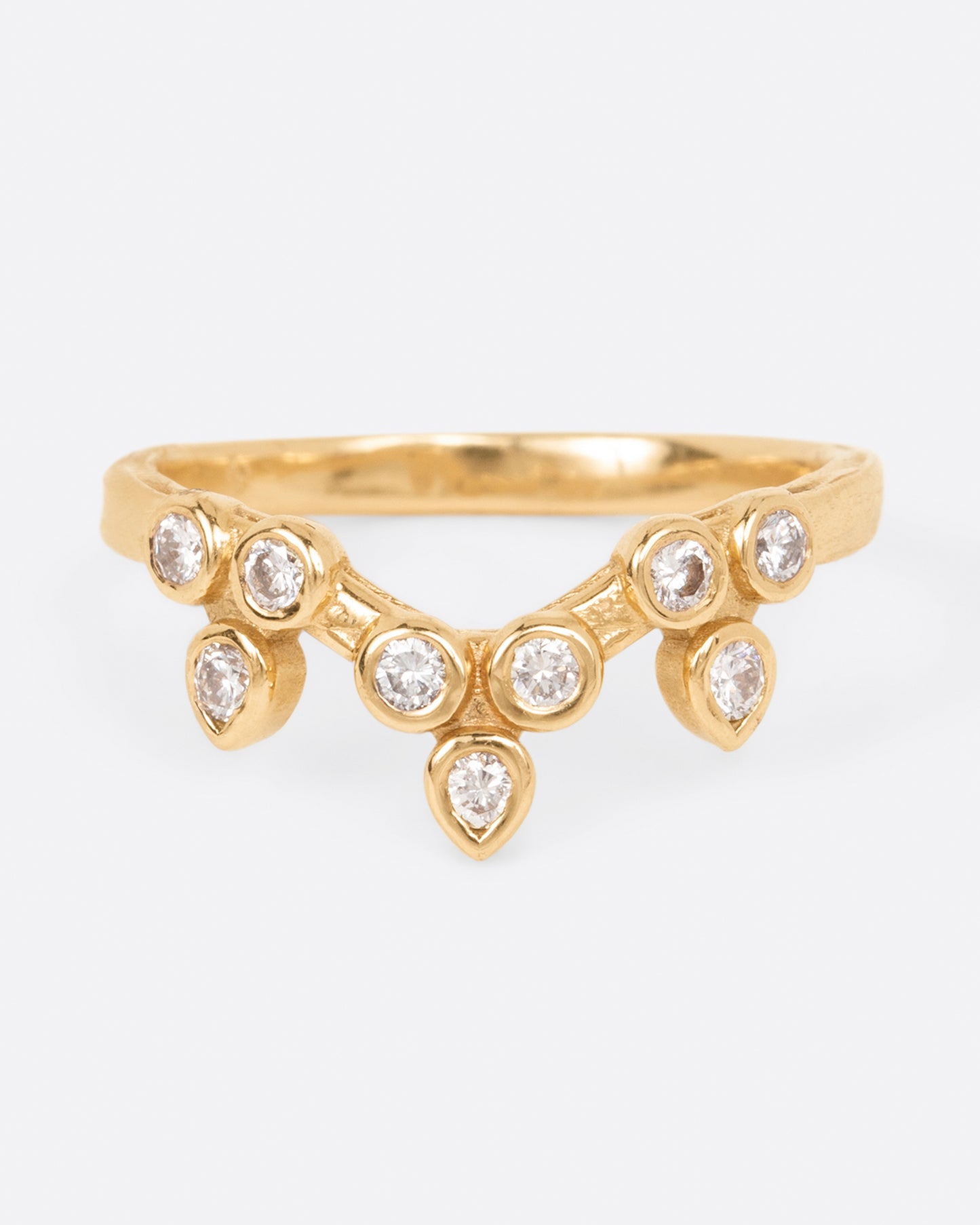 A curved yellow gold ring with a crown of round white diamonds, shown from the front.