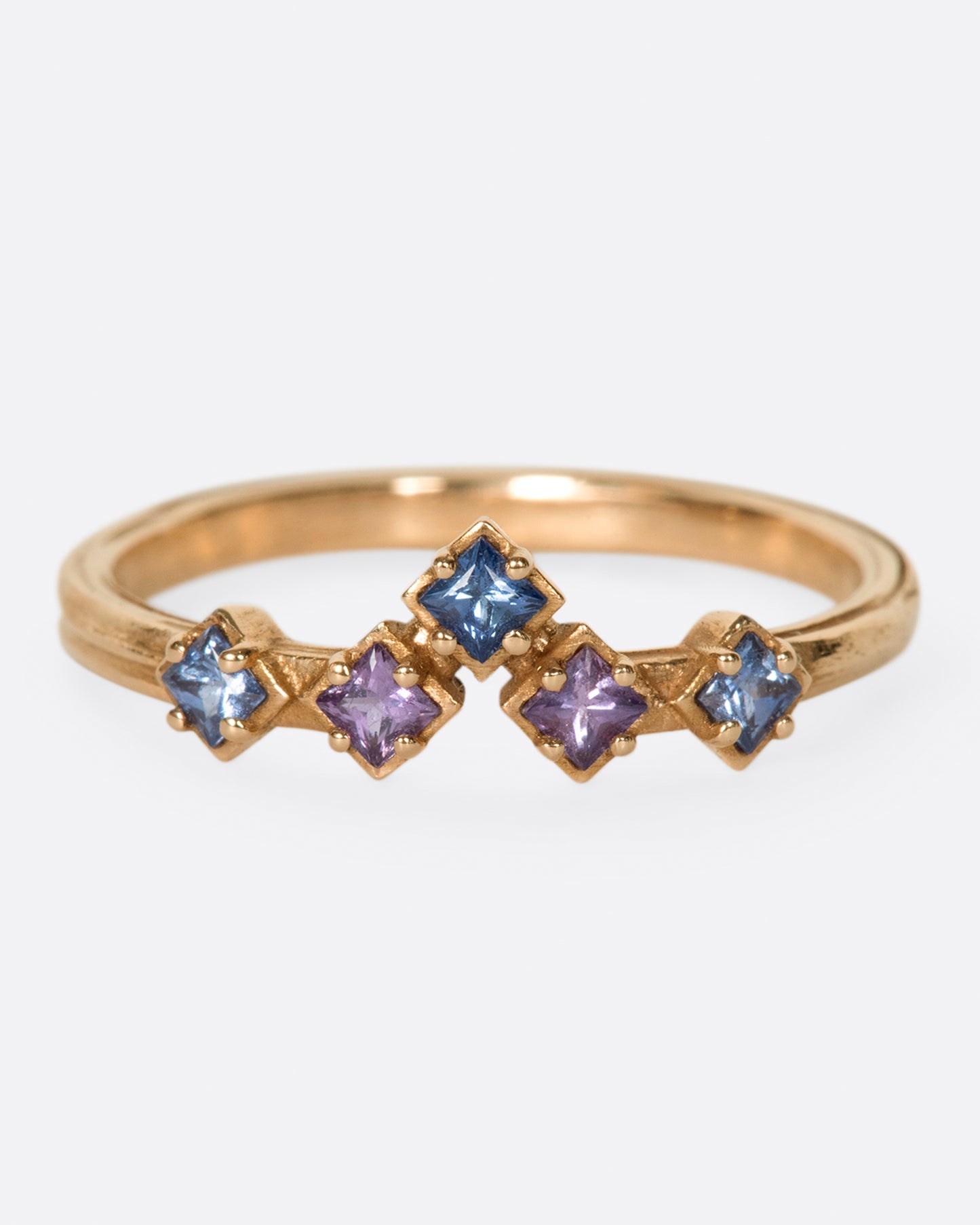 Inspired by the architecture of Tokyo, this curved band features princess cut blue and purple sapphires.