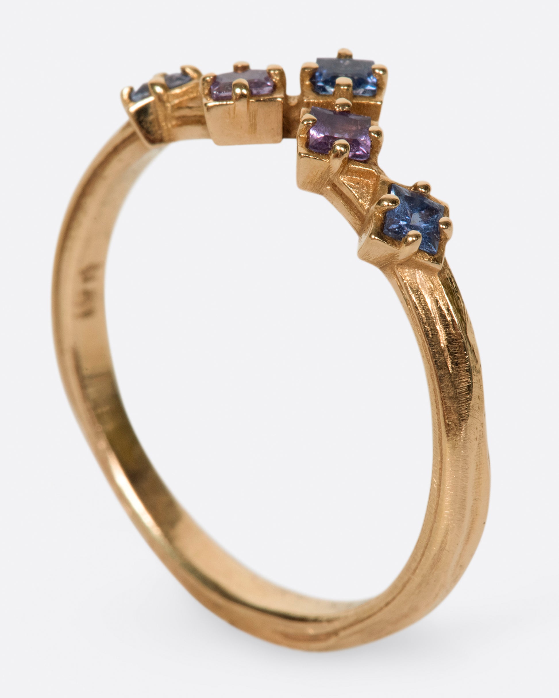 Inspired by the architecture of Tokyo, this curved band features princess cut blue and purple sapphires.