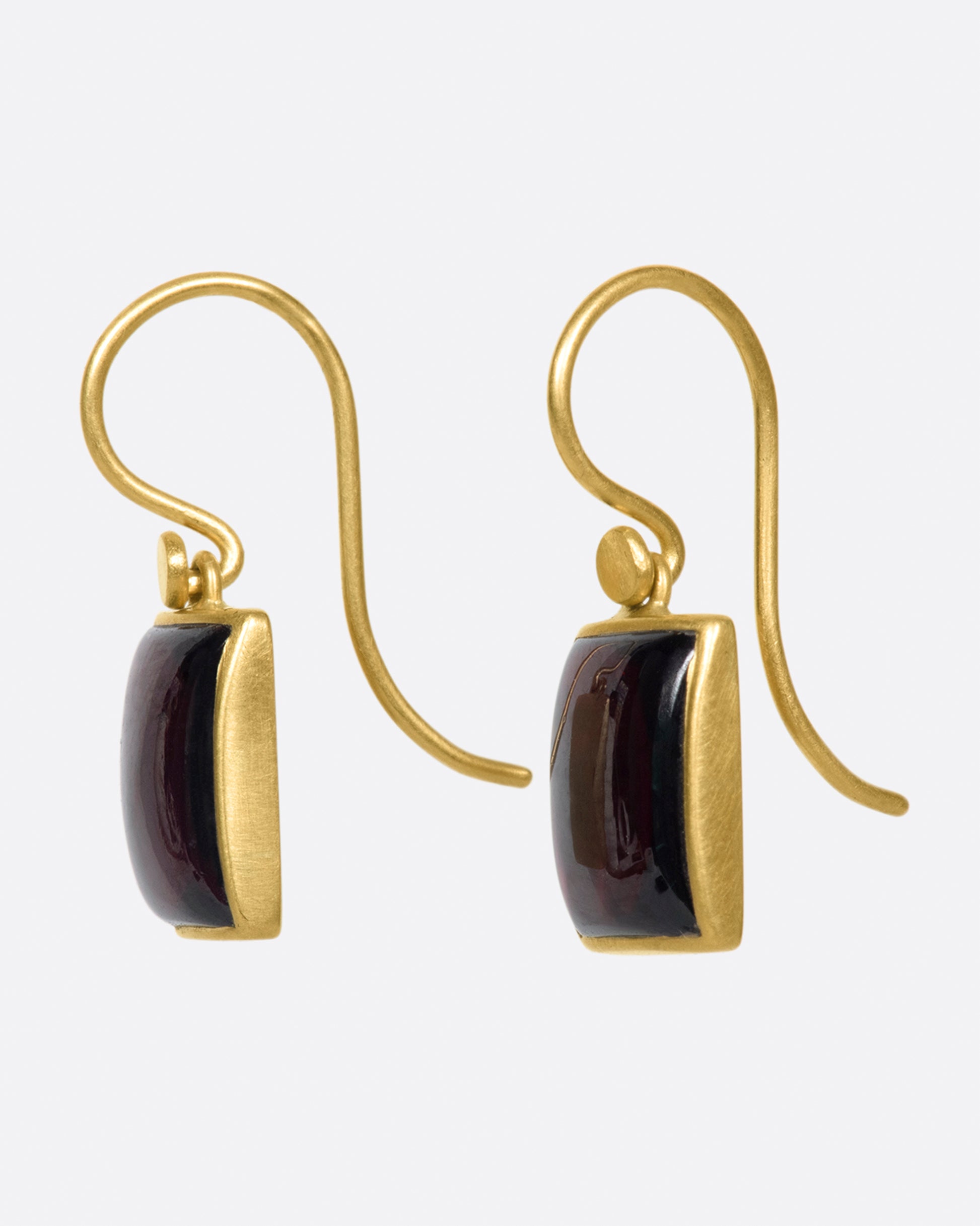 A pair of rectangular, dark red garnet cabochons set in Lola Brooks' signature bezel settings.