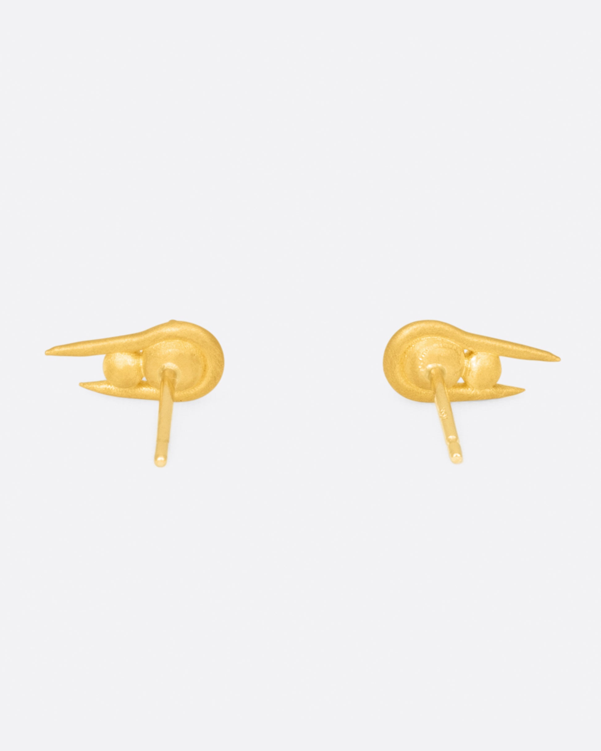 A pair of U-shaped high karat gold stud earrings with two stacked spheres at their centers, shown from the back.