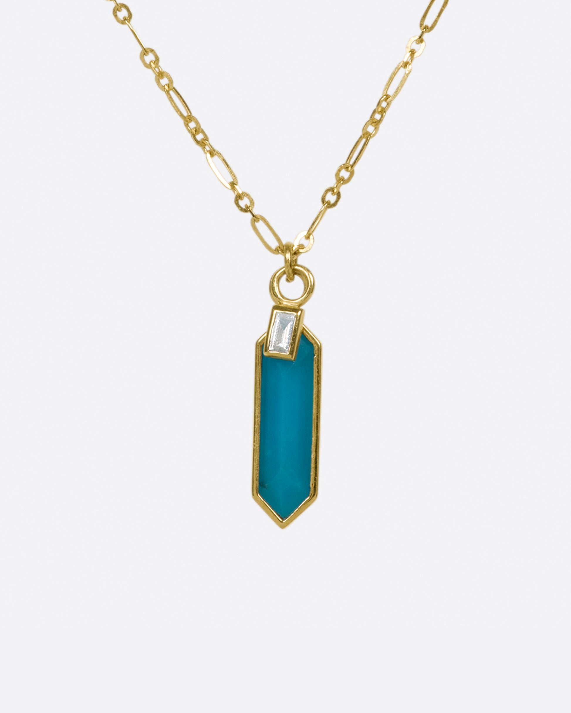 An elongated link chain necklace with a hexagonal turquoise pendant and a baguette diamond charm.