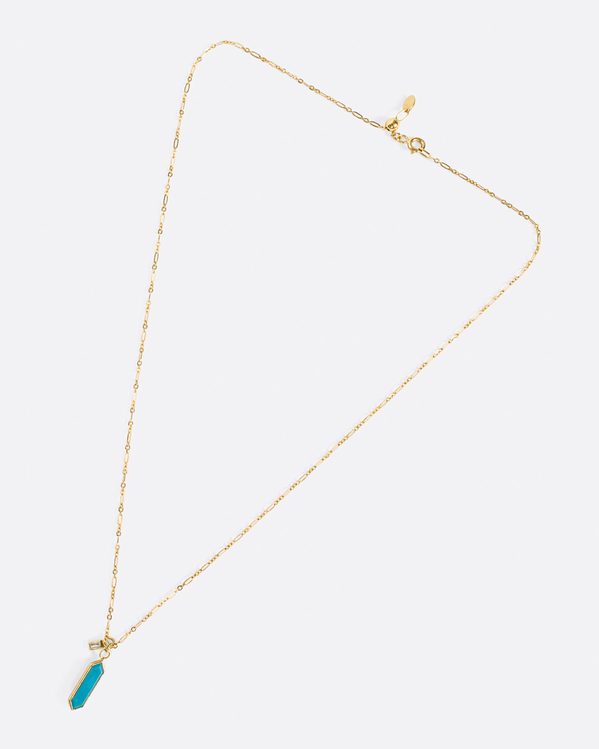 An elongated link chain necklace with a hexagonal turquoise pendant and a baguette diamond charm.