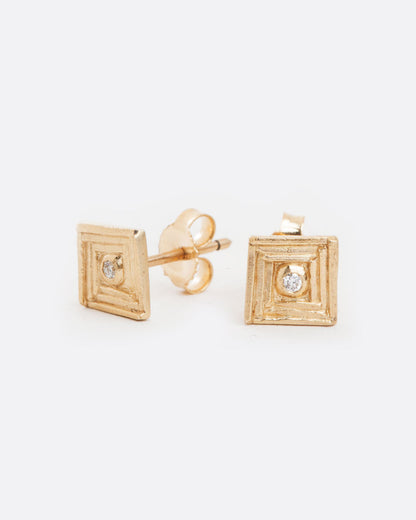 Yellow gold diamond square stud earrings, the pair laid flat showing the posts