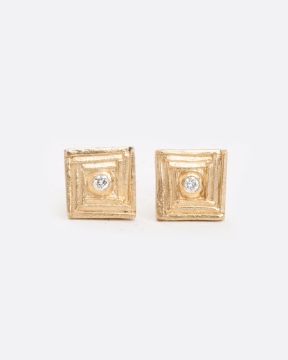 DMD Metal square stud earrings in yellow gold, textured stepped squares with a diamond at the center