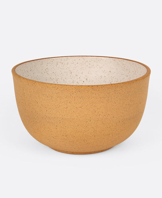 A stoneware salad bowl with a raw exterior and white glazed interior, shown from the side.