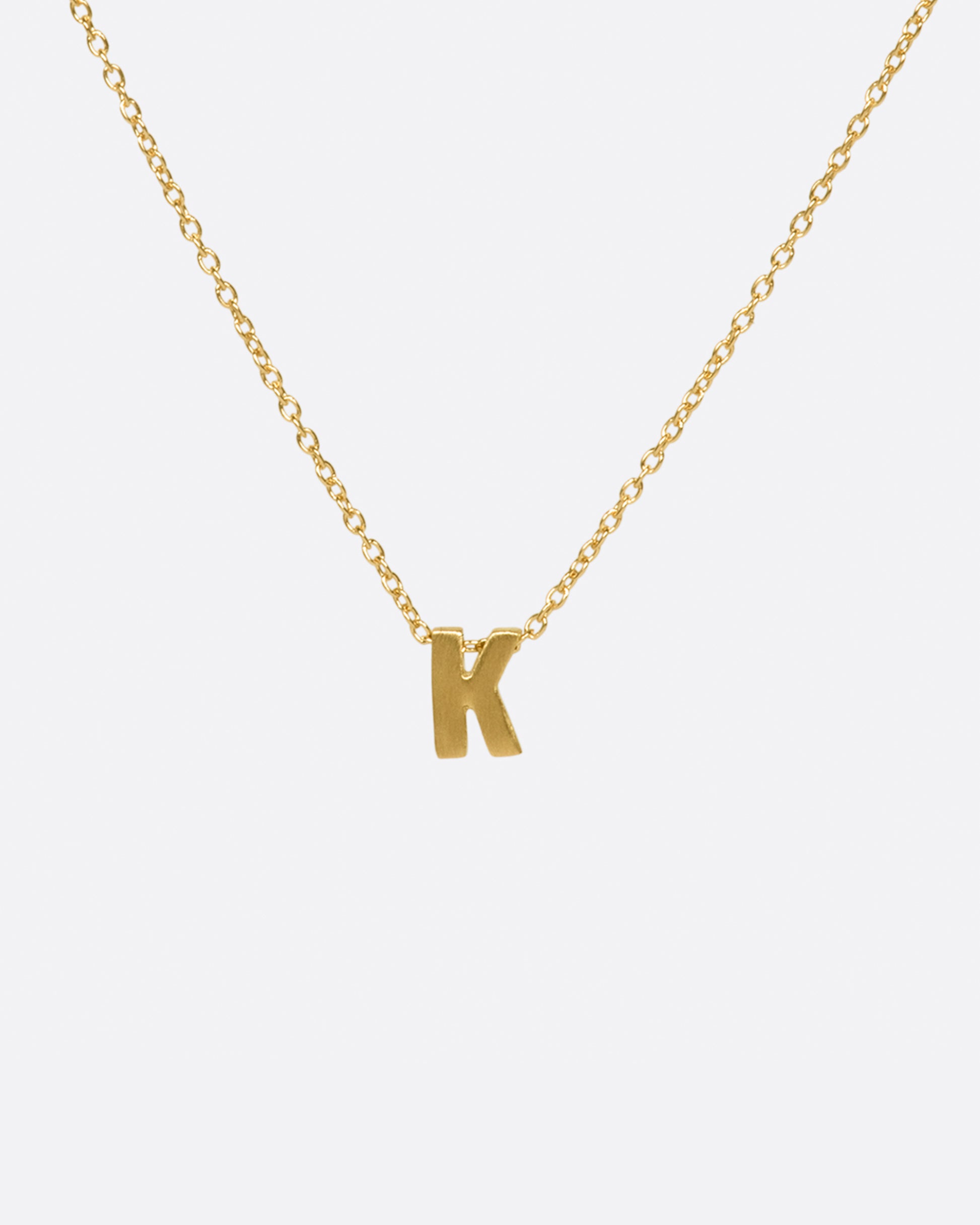 This micro initial necklace features a block letter of your choice hanging from a cable chain with an optional separate bezel set diamond tag.