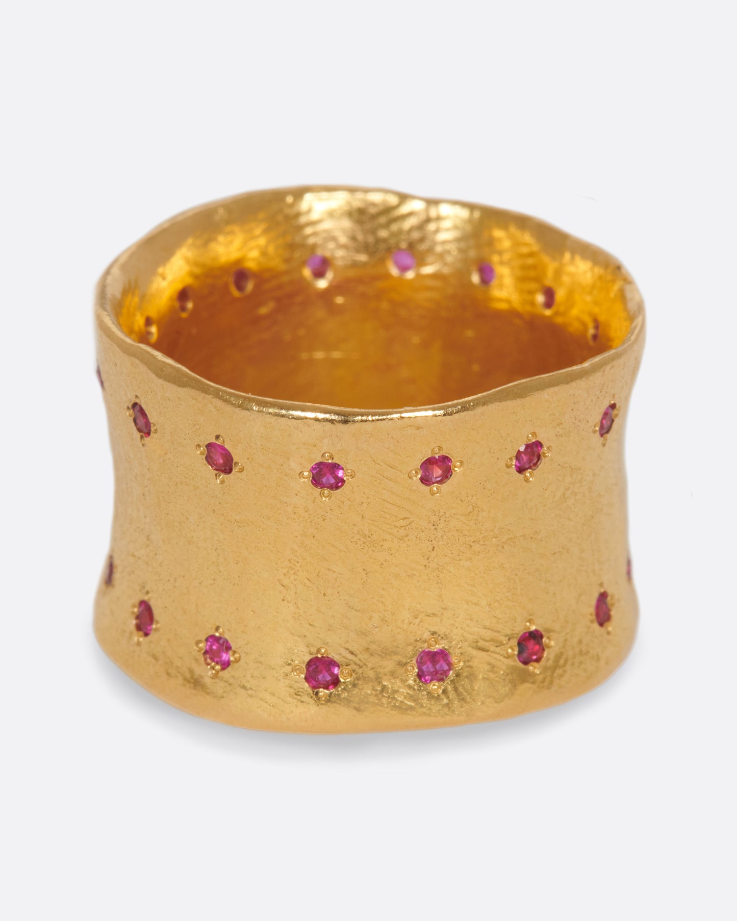 A slightly concave 22k gold band lined with thirty two rubies.