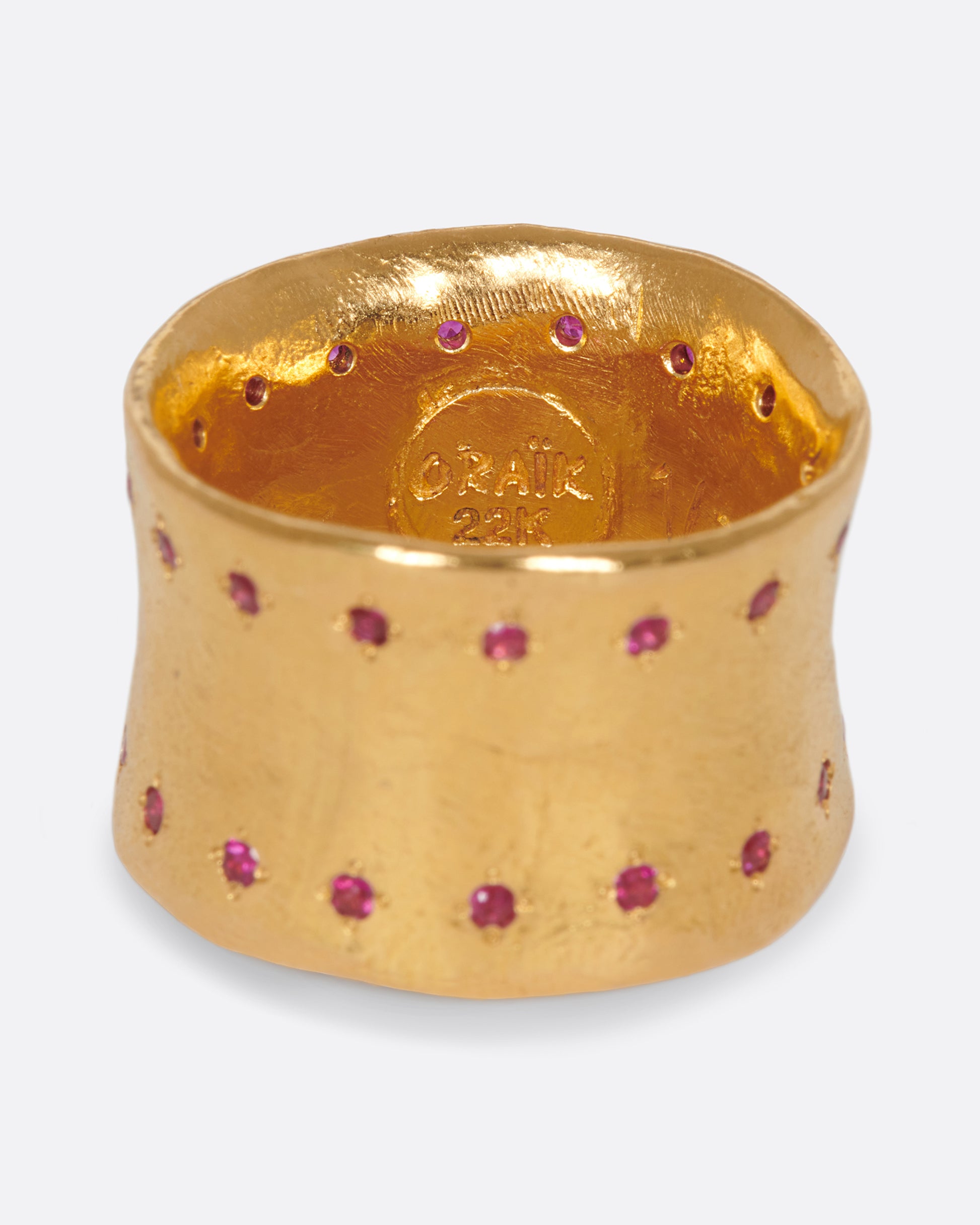 A slightly concave 22k gold band lined with thirty two rubies.