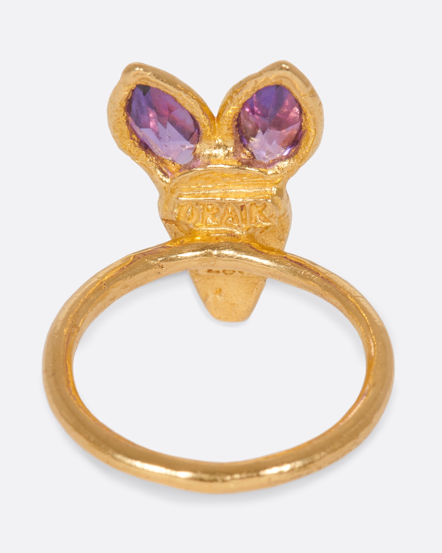 A little, hand-formed rabbit ring with big amethyst ears and red sapphire eyes.