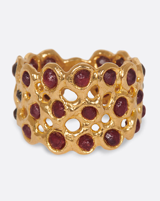 A ring made of a web of dark red garnet nuggets set in high karat gold bezels.