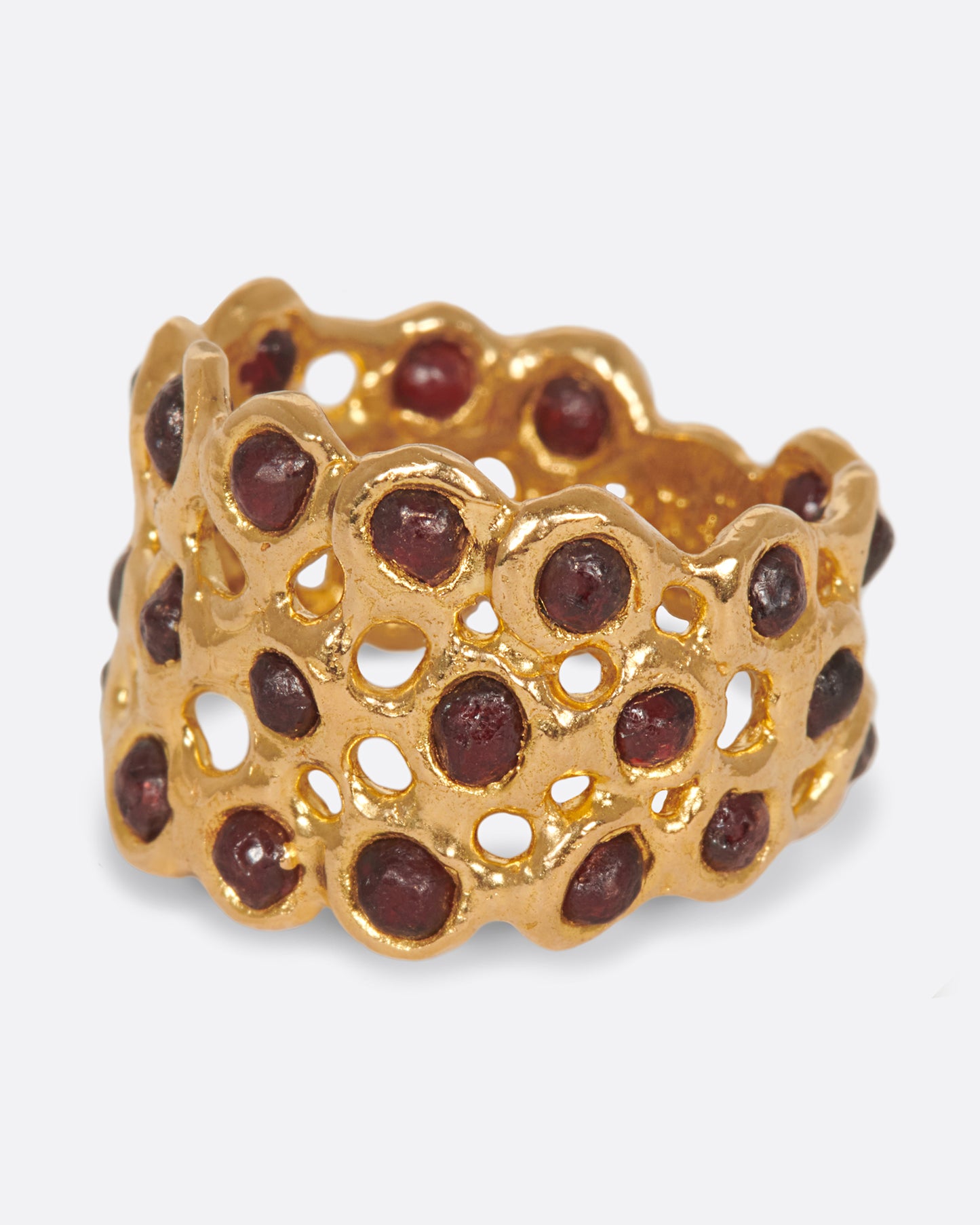 A ring made of a web of dark red garnet nuggets set in high karat gold bezels.