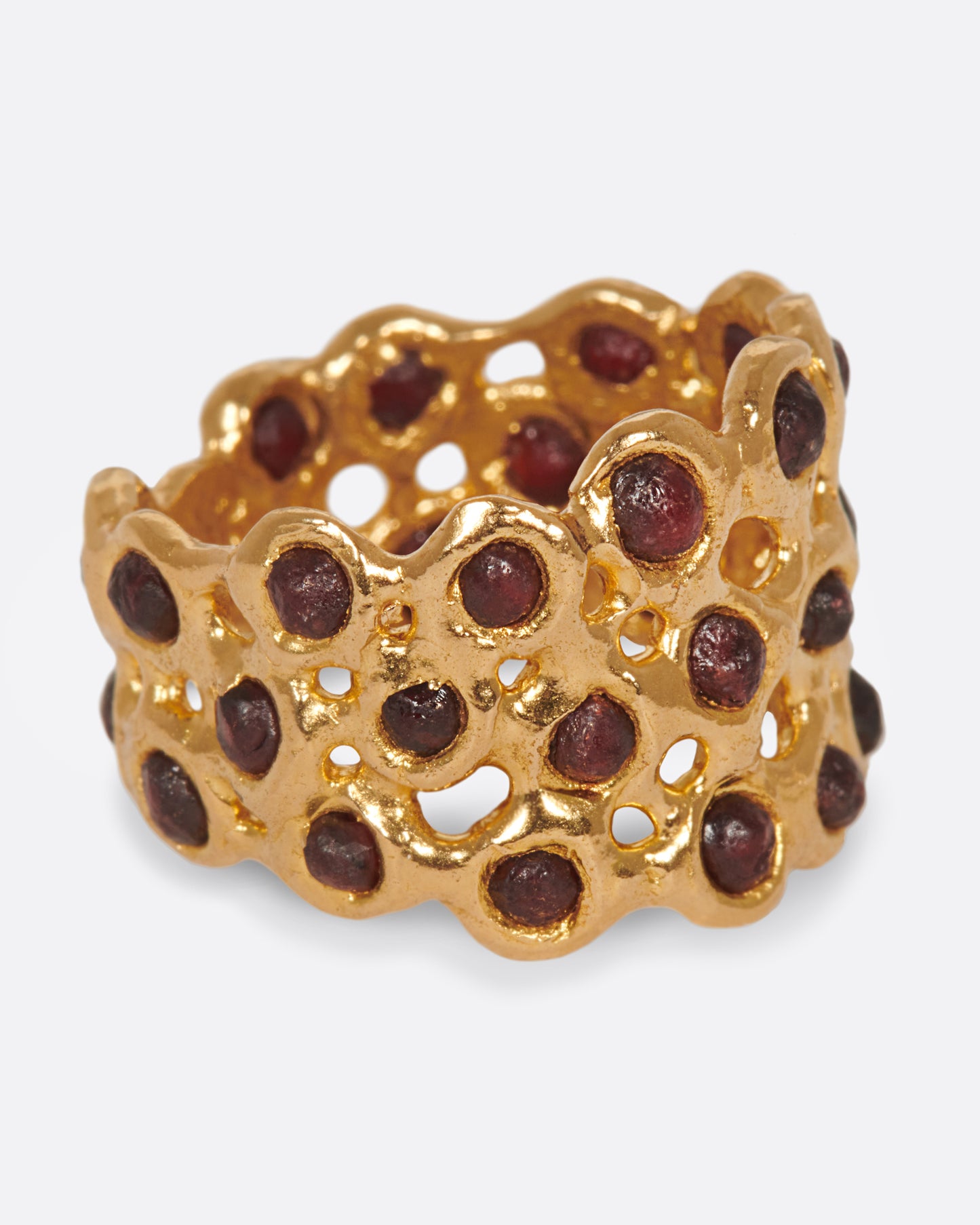 A ring made of a web of dark red garnet nuggets set in high karat gold bezels.