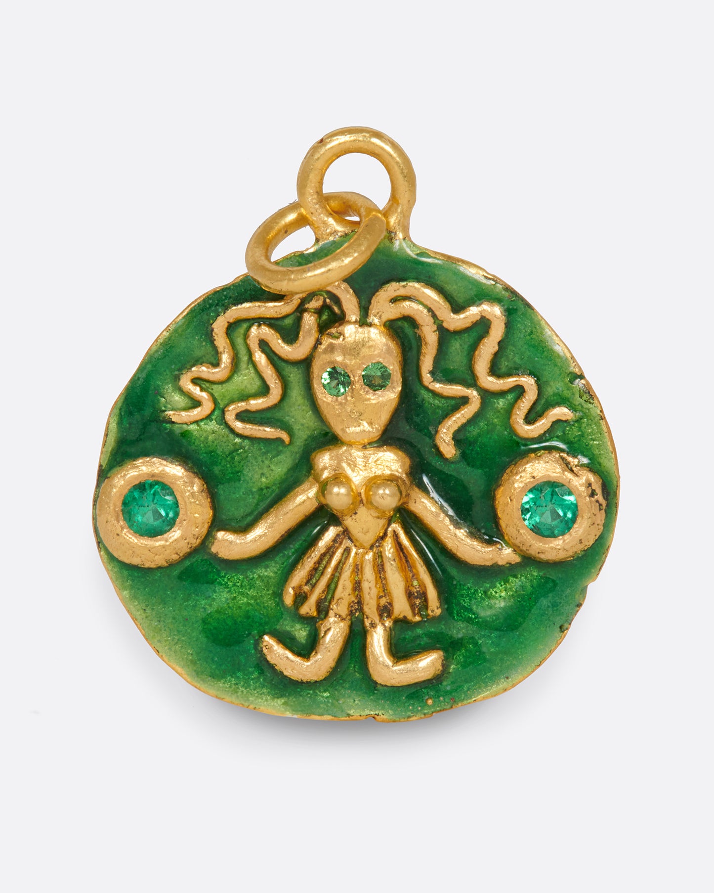 A round, high karat gold medallion pendant featuring a Virgo icon holding two tsavorite garnets.