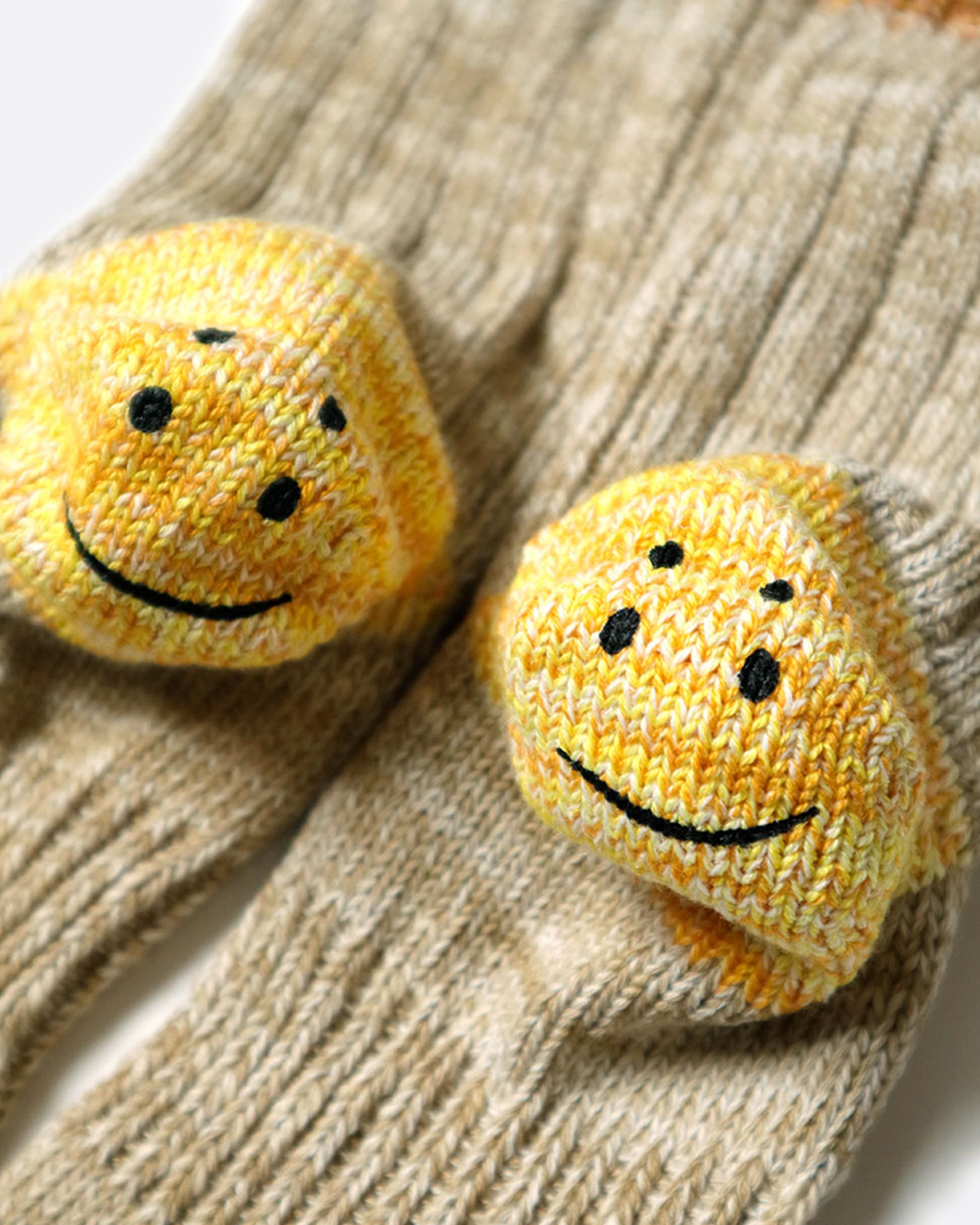 A close up of the smiley heels of beige ribbed tube socks.